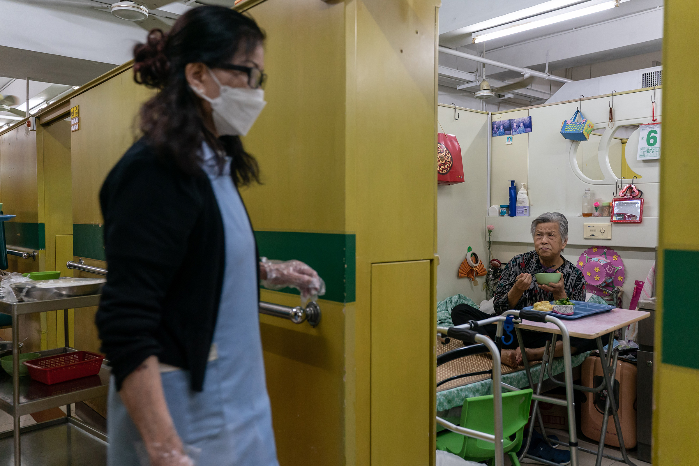 Yip Fung-cheung, 82, a resident of Hong Kong's Kei Tak (Tai Hang) Home for the Aged, eats dinner in her dormitory space. (Anthony Kwan for TIME)