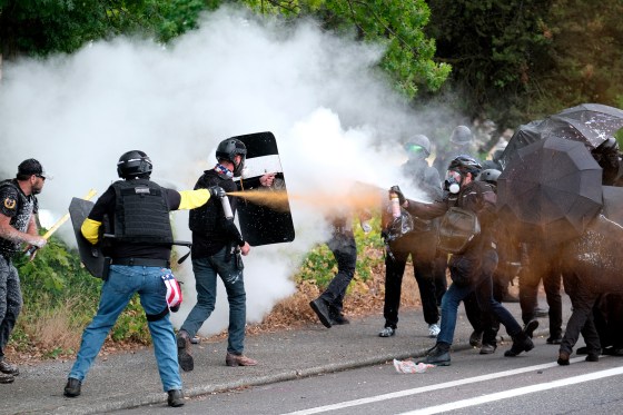 Members of Proud Boys and anti-fascist protesters spray mace at each other during clashes in Portland, Ore., on Aug. 22, 2021.