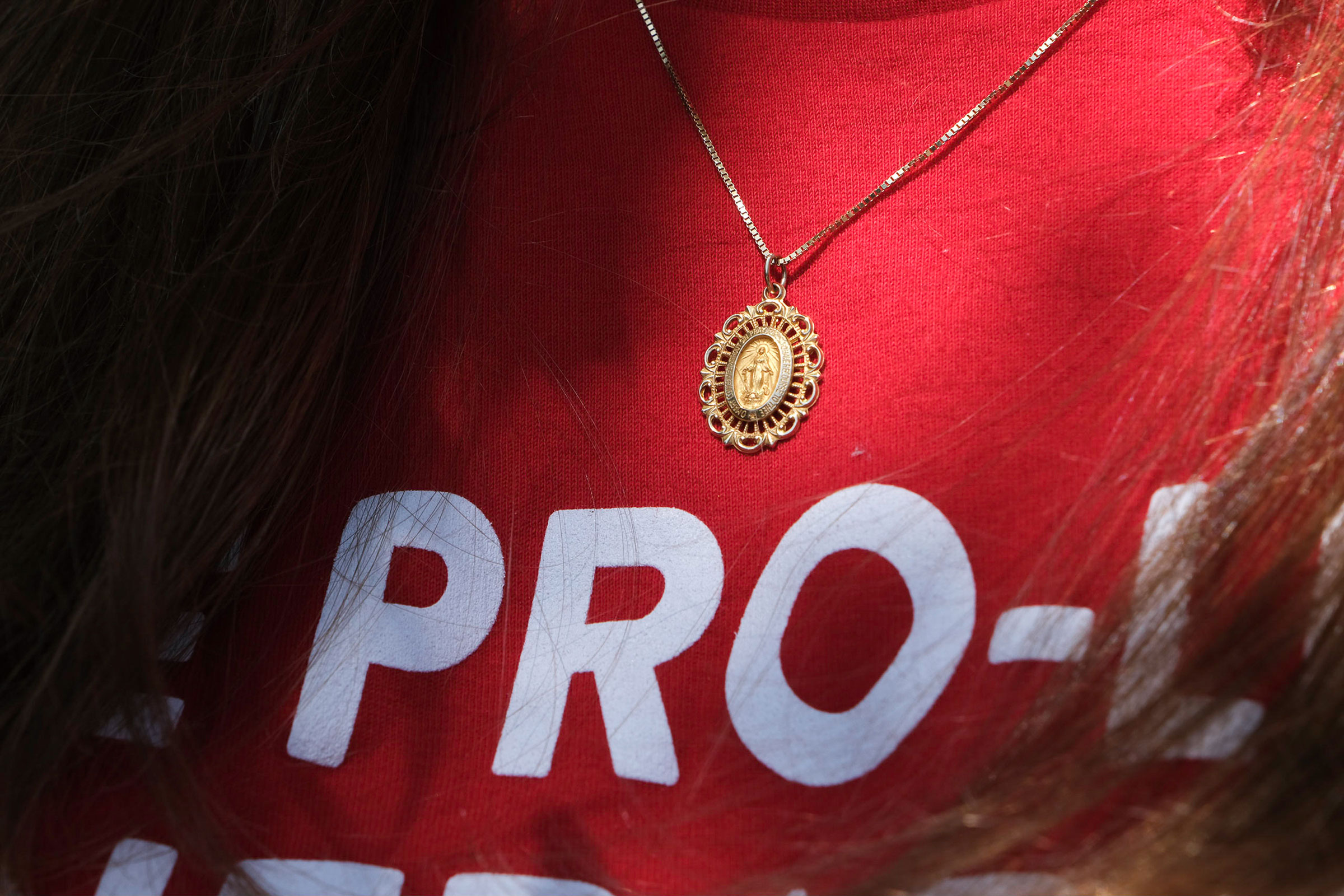 A volunteer with Students for Life of America wears a Miraculous Medal pendant and a shirt that says "The Pro-Life Generation Votes" while canvassing on July 23. (Arin Yoon for TIME)