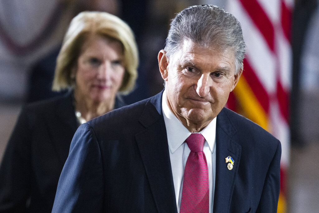 Sen. Joe Manchin, D-W.Va., and Sen. Shelley Moore Capito, R-W.Va., pay their respects as the flag-draped casket bearing the remains of Hershel W. "Woody" Williams, lies in honor in the U.S. Capitol, Thursday, July 14, 2022 in Washington. (Tom Williams—Pool/AP)