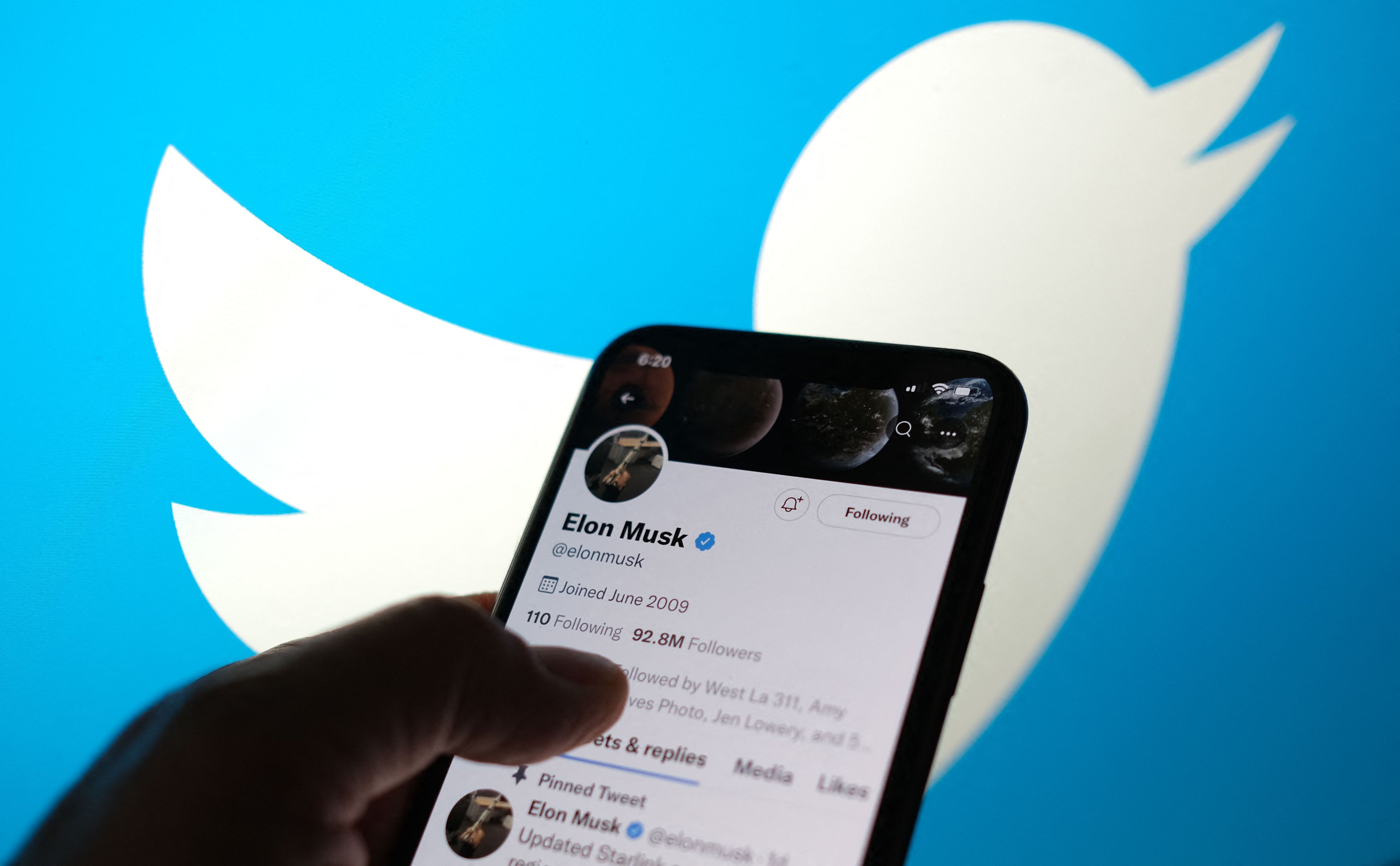 Elon Musks Twitter account with a Twitter logo in the background in Los Angeles. (AFP / Getty Images)
