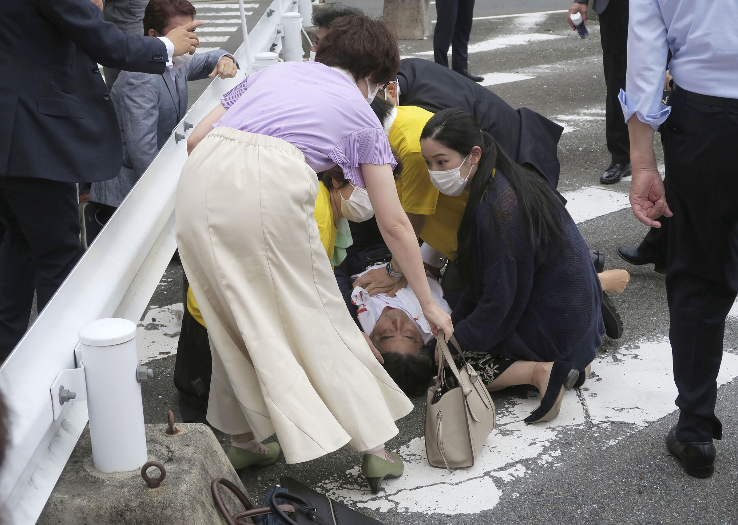 Japan’s former Prime Minister Shinzo Abe, center, falls on the ground after being shot in Nara, western Japan Friday, July 8, 2022. (Kyodo News/AP)