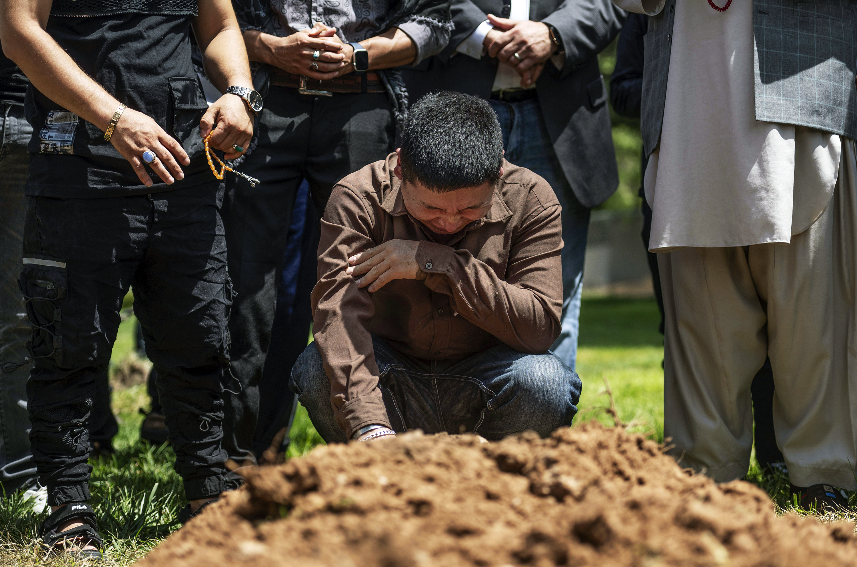 Altaf Hussain cries over the grave of his brother Aftab Hussein at Fairview Memorial Park in Albuquerque, N.M., on Friday, Aug. 5, 2022. Aftab was one of four Muslim men shot and killed in Albuquerque since November. (Chancey Bush–The Albuquerque Journal/AP)