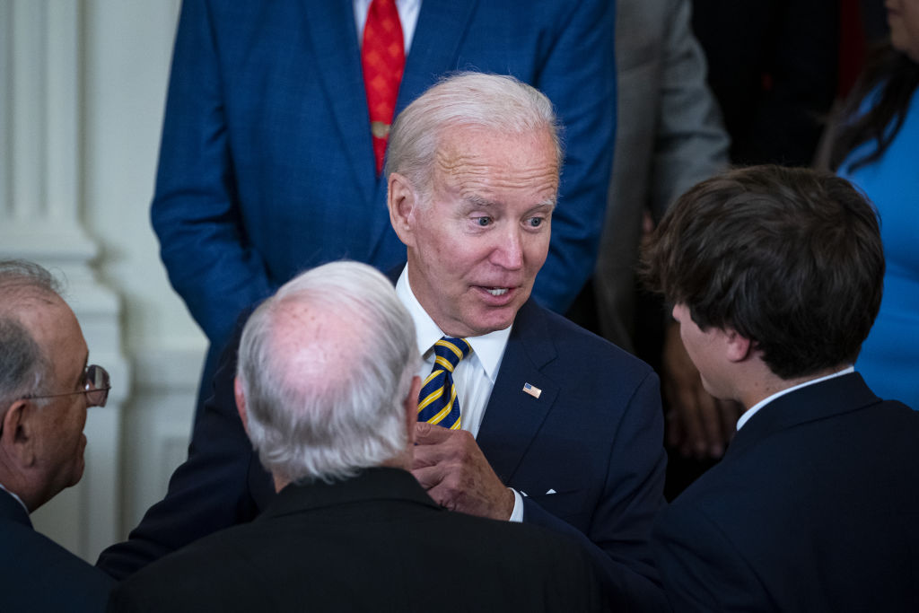 US President Joe Biden speaks with his grandson Robert Biden II after signing a bill Legislation giving veterans exposed to toxic burn pits access to expanded health benefits in the East Room of the White House in Washington, D.C. on Aug. 10, 2022. (Al Drago—Bloomberg via Getty Images)