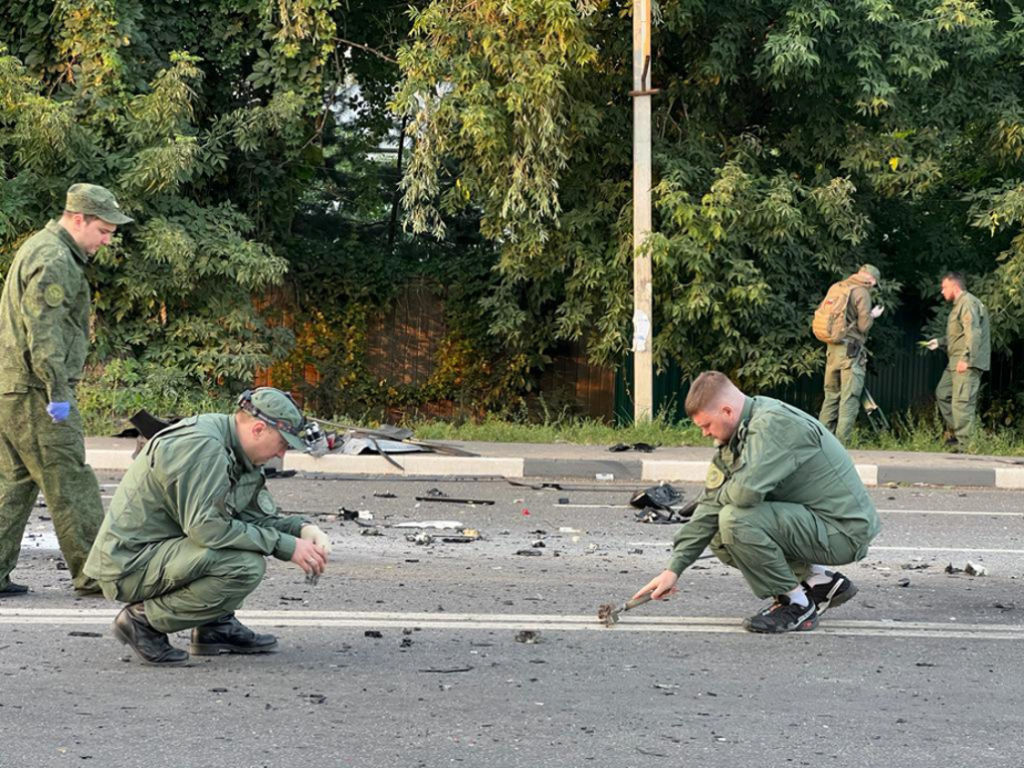 Russian officials investigate the scene after the car of Darya Dugina, daughter of Alexander Dugin, Russian political scientist and ally of President Vladimir Putin, exploded on Mozhayskoye highway in Moscow on Aug. 21, 2022. (Russian Investigative Committee/Anadolu Agency via Getty Images)