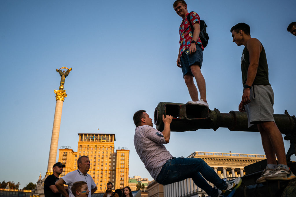 In this photograph taken on Aug. 21, 2022, people climb atop a destroyed Russian vehicle at Kyiv's "Maidan" Independence Square, that has been turned into an open-air military museum ahead of Ukraine's Independence Day on Aug. 24. (Dimitar Dilkoff—AFP via Getty Images)