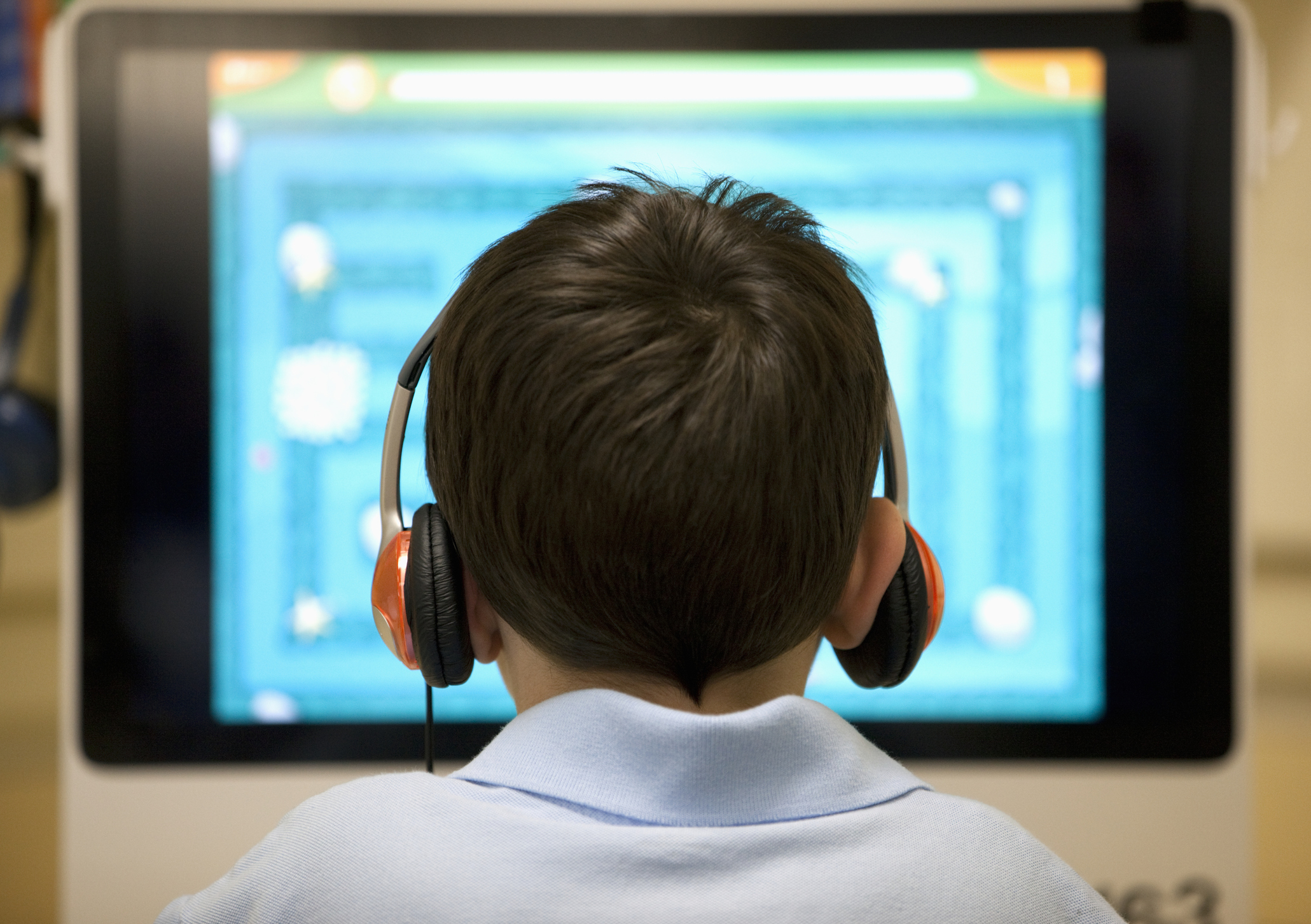 Rear view of a six year old boy at a computer workstation. (Getty Images)