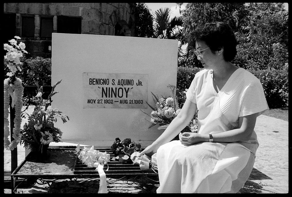 Corazon Aquino places flowers by the tomb of her assassinated husband Ninoy, on the outskirts of Manila, Dec. 4, 1985. (Alex Bowie/Getty Images)