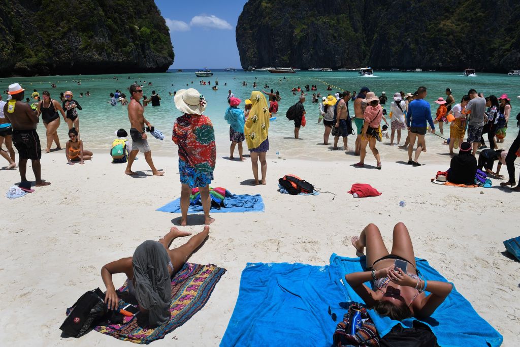 This photo taken on April 9, 2018 shows tourists sunbathing and walking on Maya Bay, Phi Phi, Thailand (LILLIAN SUWANRUMPHA/AFP via Getty Images)
