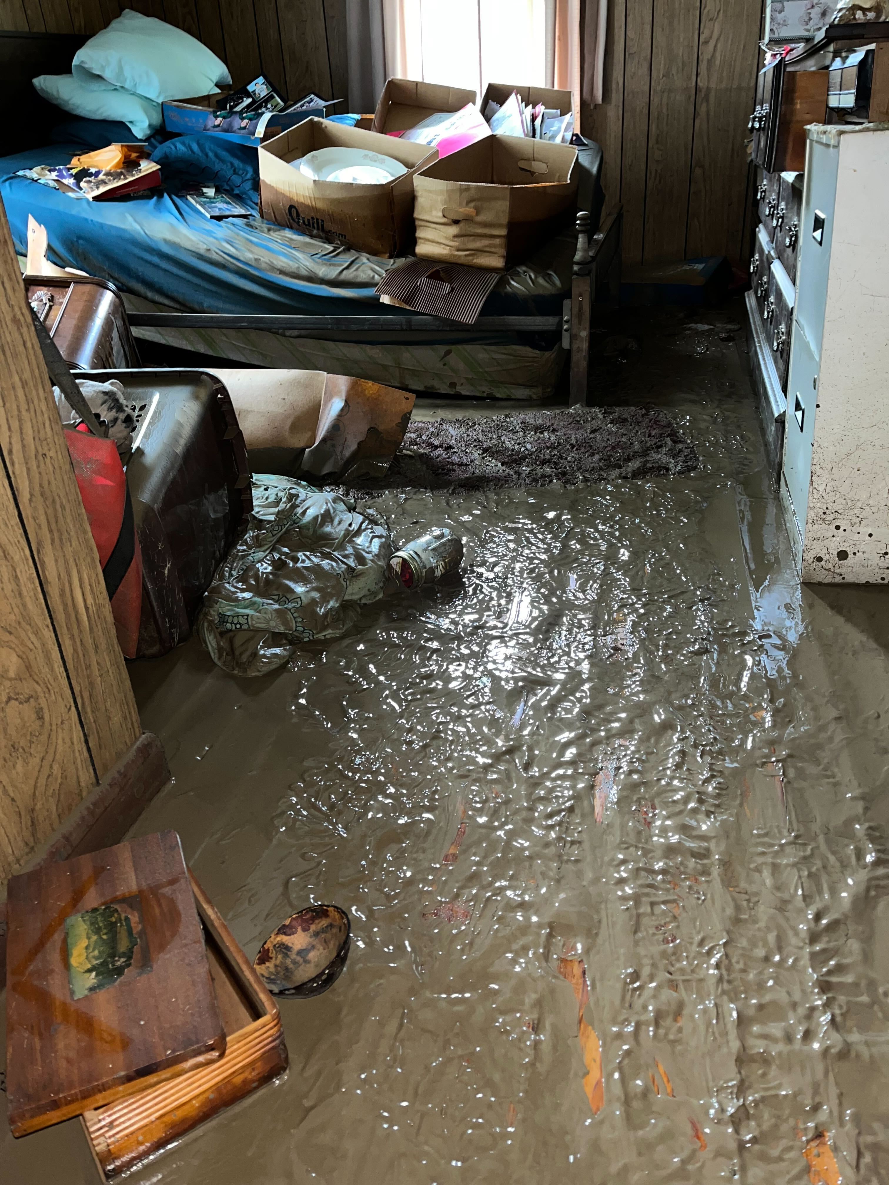The flooded interior of Bolen's grandfather's house is covered in mud. The family has boxes of family photos and documents stacked on the bed that they attempted to save in Knott County, Kentucky, July 29, 2022. (Shared by Lakyn Bolen)