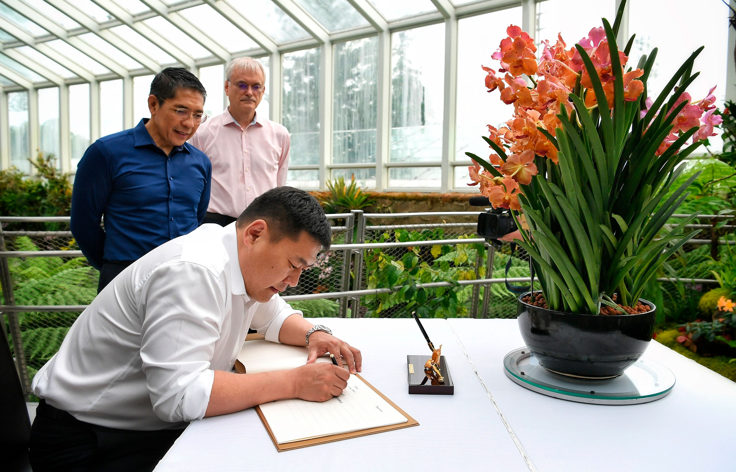 Mongolian Prime Minister Oyun-Erdene Luvsannamsrai signing the guest book at the National Orchid Garden during his four-day visit to Singapore, on July 8, 2022. (Singapore Press/AP)