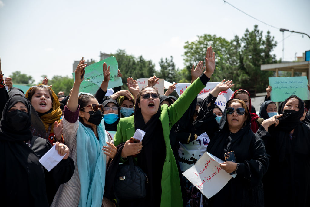 Taliban fighters fire into the air as they disperse a rare rally by women as they chant "Bread, work and freedom" and march in front of the education ministry building, days ahead of the first anniversary of the hardline Islamists' return to power, on August 13, 2022 in Kabul, Afghanistan. (Nava Jamshidi/Getty Images)