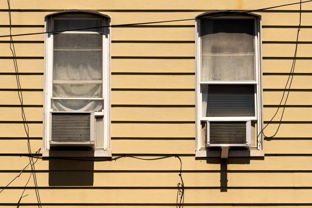 Air conditioners are seen in residential windows on July 28, 2020 in New York City, when temperatures soared above 90 degrees. Most city dwellers rely on these units to cool their homes. (Scott Heins—Getty Images)