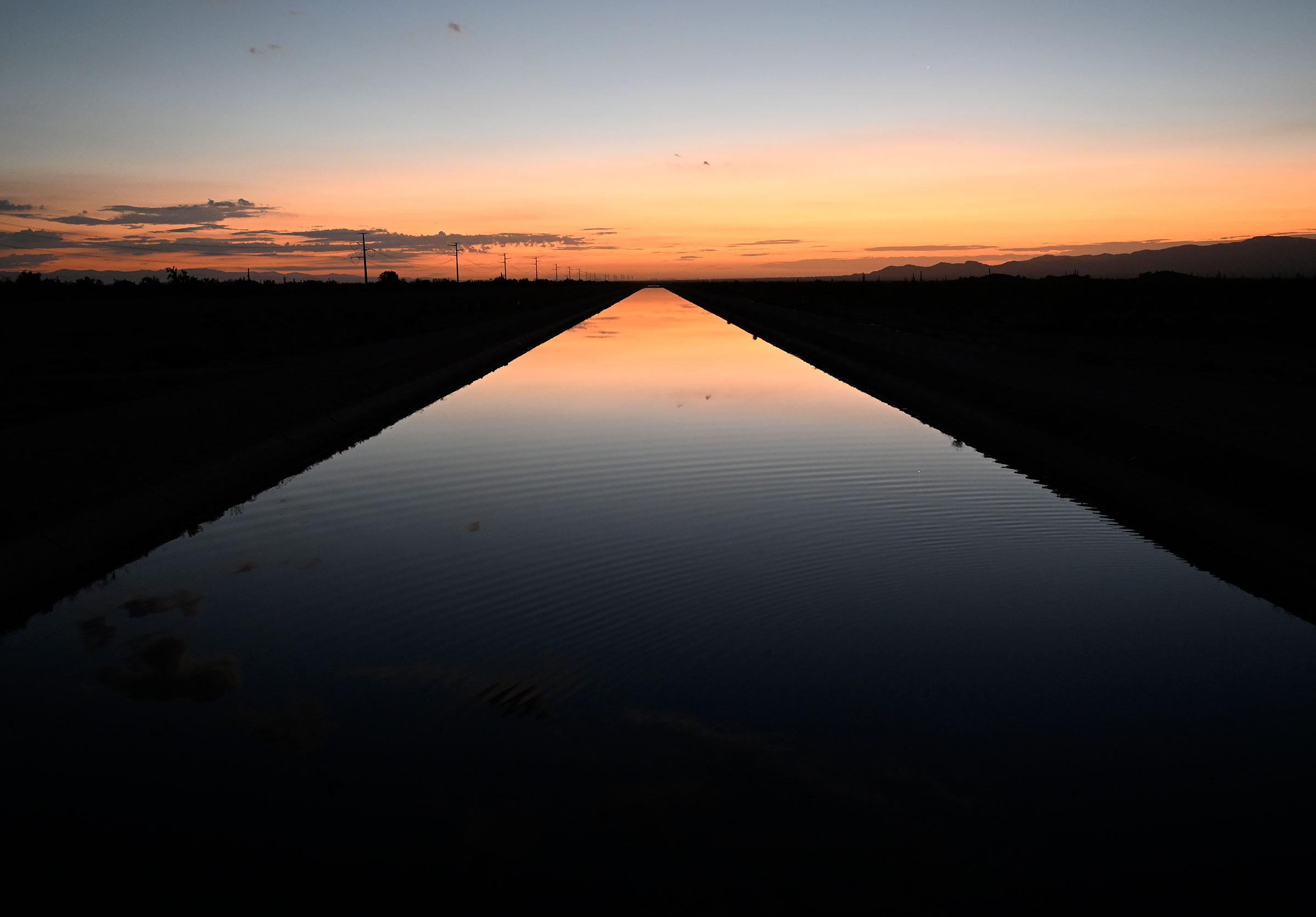 The sun rises over a canal that is full of Colorado River water on Aug. 17, 2022 near Buckeye, Ariz. (RJ Sangosti—MediaNews Group/The Denver Post/Getty Images)