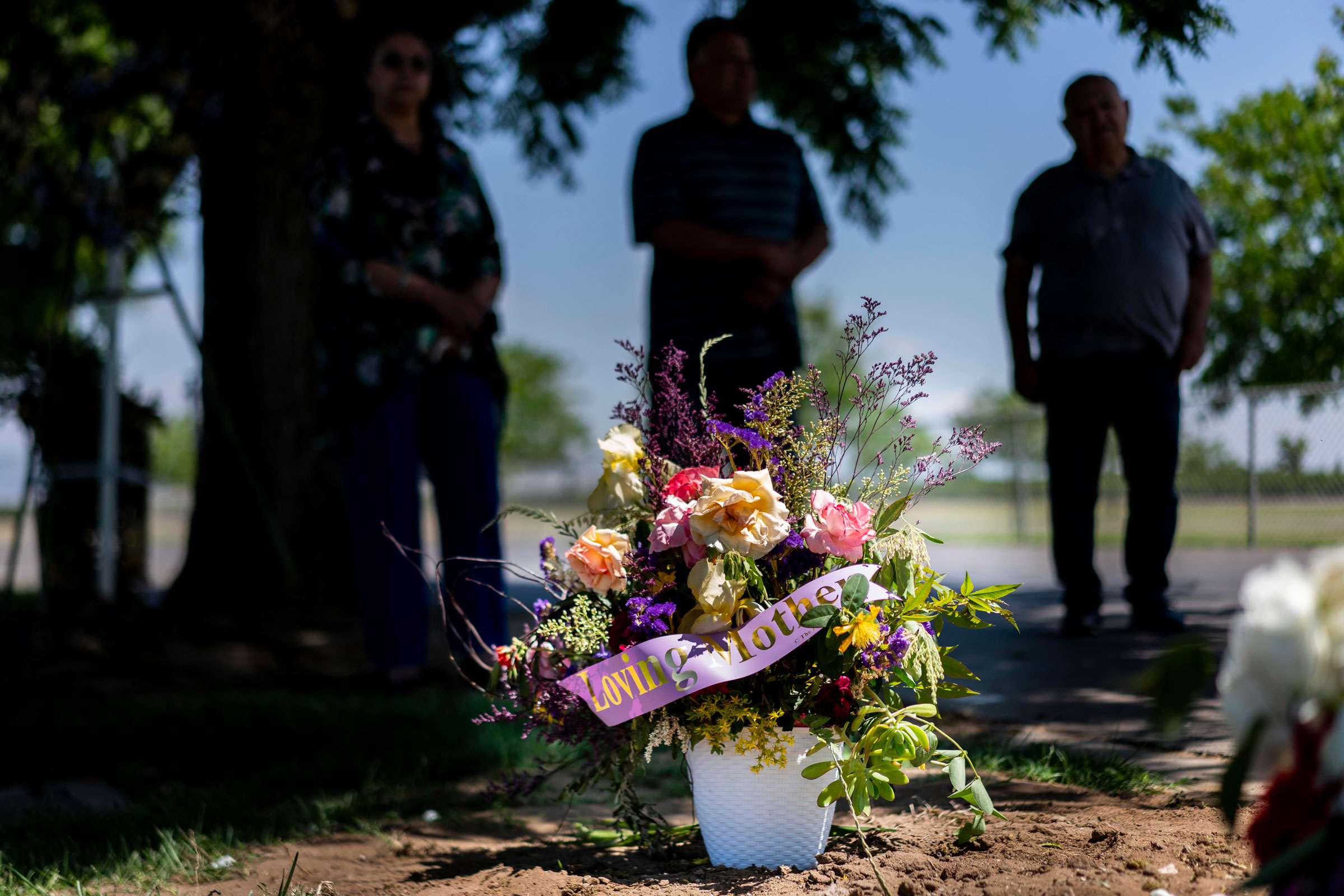 A family mourning at a grave site at Smith Mountain Cemetery in Dinuba, California