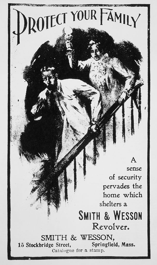 Frightened husband with gun and wife on stairway, "Protect Your Family", advertisement, Smith &amp; Wesson, circa 1901. (Universal History Archive/Universal Images Group—Getty Images)