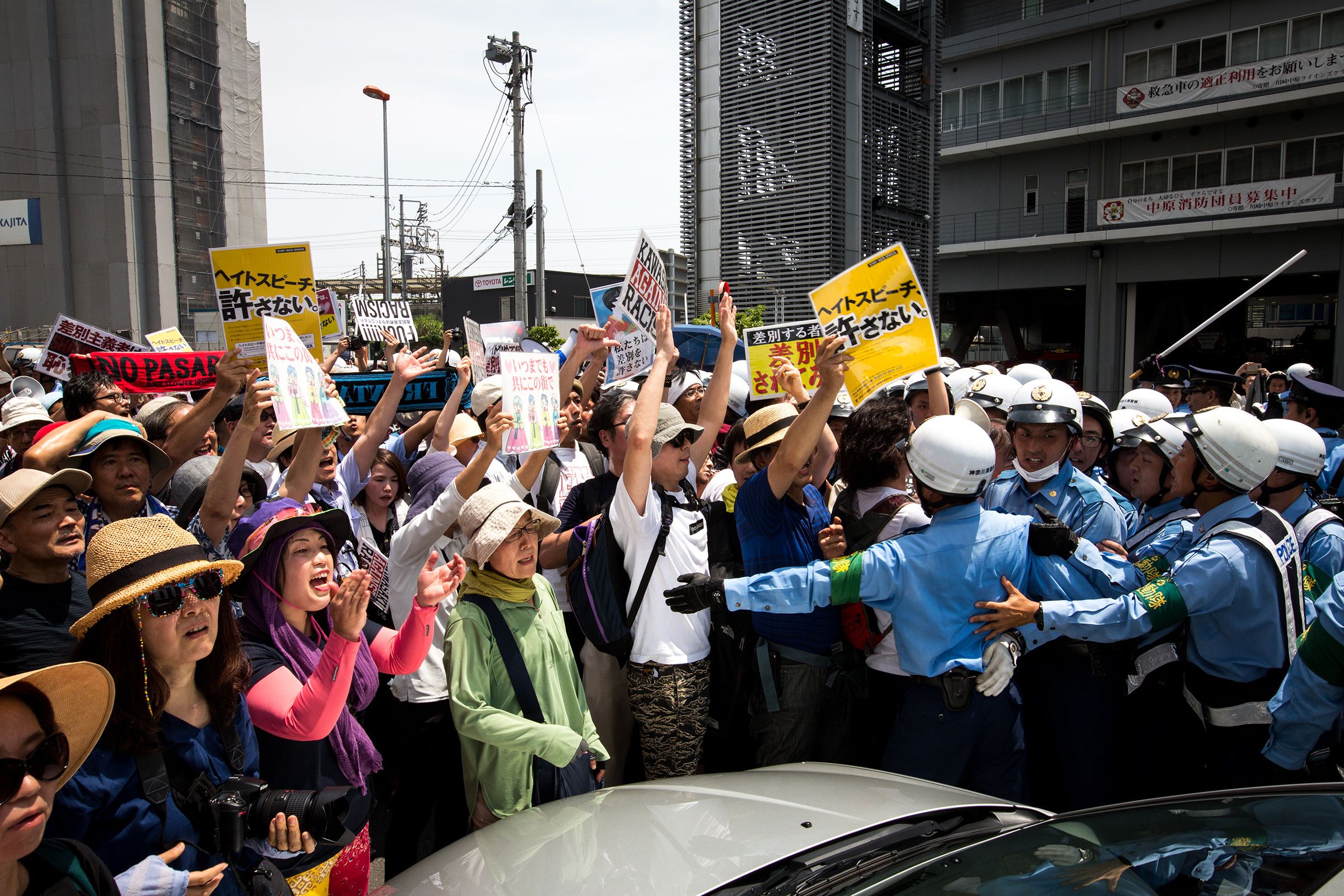 Anti-racist groups (L) try to block Japanese nationalists from marching on the street during a rally demanding an end to hate speech in Kawasaki, Japan, on July 16, 2017. Scuffles erupted when right-wing activists marched with their slogans, flags, and racist speech, forcing police to intervene. (Richard Atrero de Guzman—NurPhoto/Getty Images)