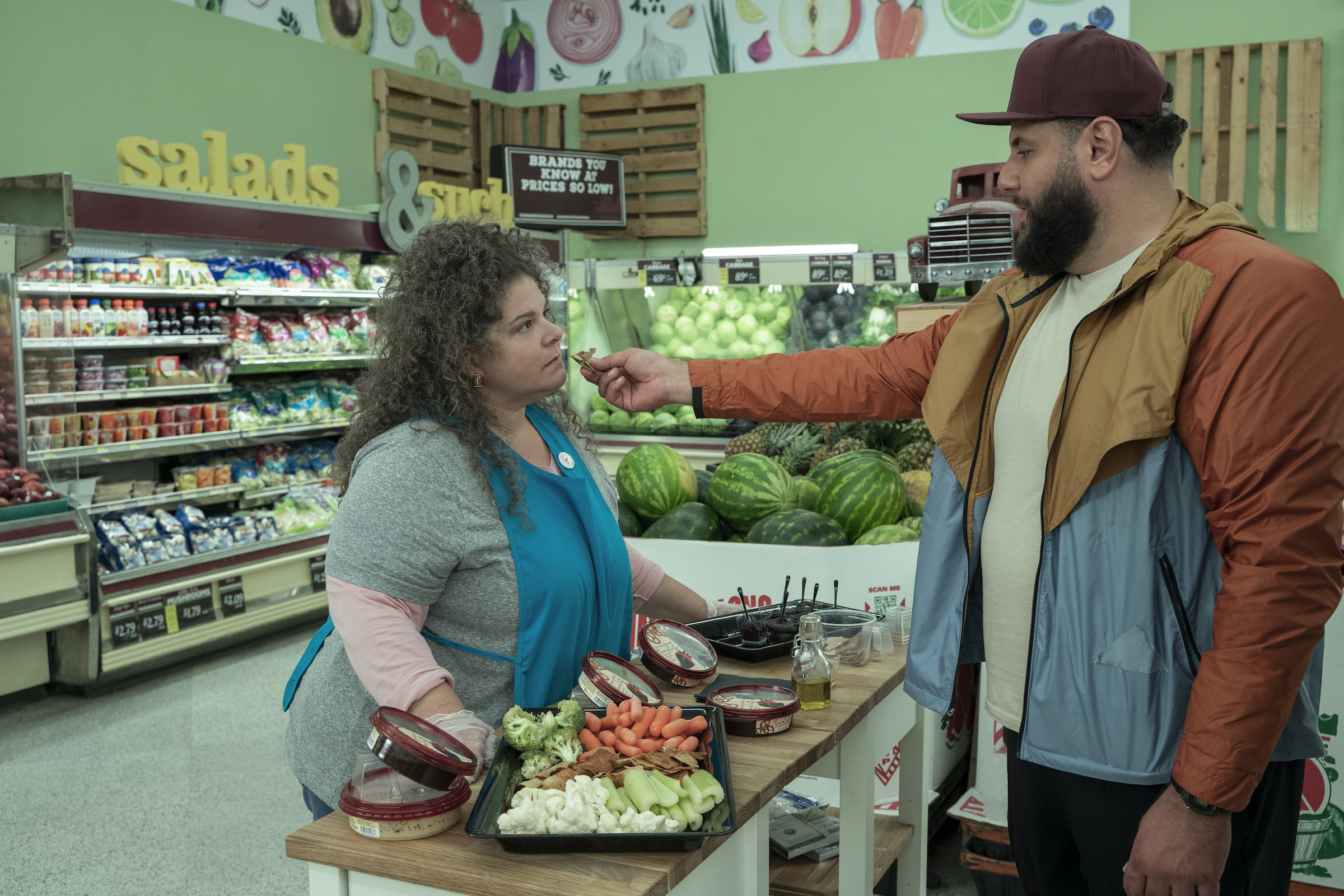 Mo feeds the grocery store worker a piece of pita dipped in his mother's homemade olive oil. (Rebecca Brenneman—Netflix)