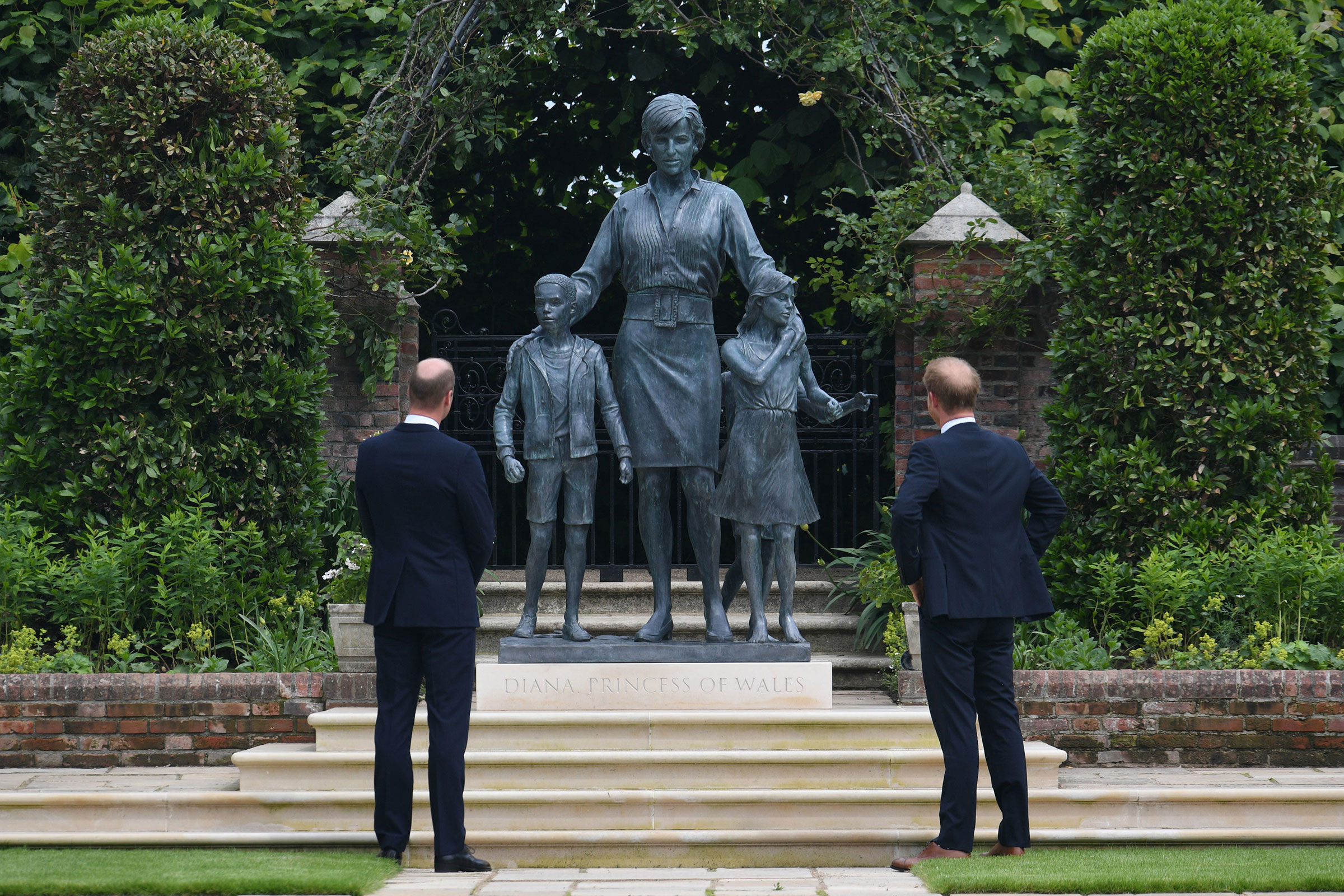 Prince William and Prince Harry look at a statue they commissioned of their mother Diana, in the Sunken Garden at Kensington Palace, on what would have been her 60th birthday on July 1, 2021. (Dominic Lipinski—WPA Pool/Getty Images)