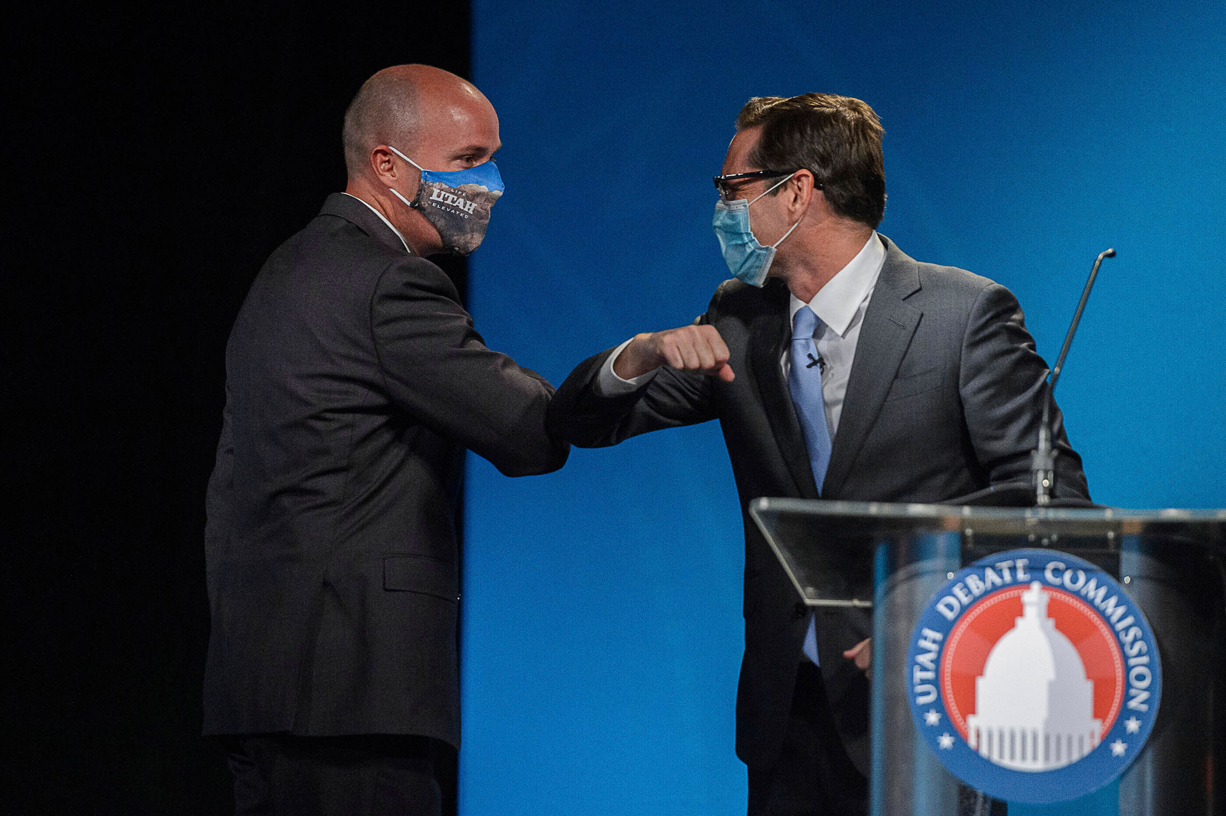 Republican Lt. Gov. Spencer Cox, left, and Democrat Chris Peterson, rivals to become Utah's next governor, bump elbows after facing each other in a prime-time debate