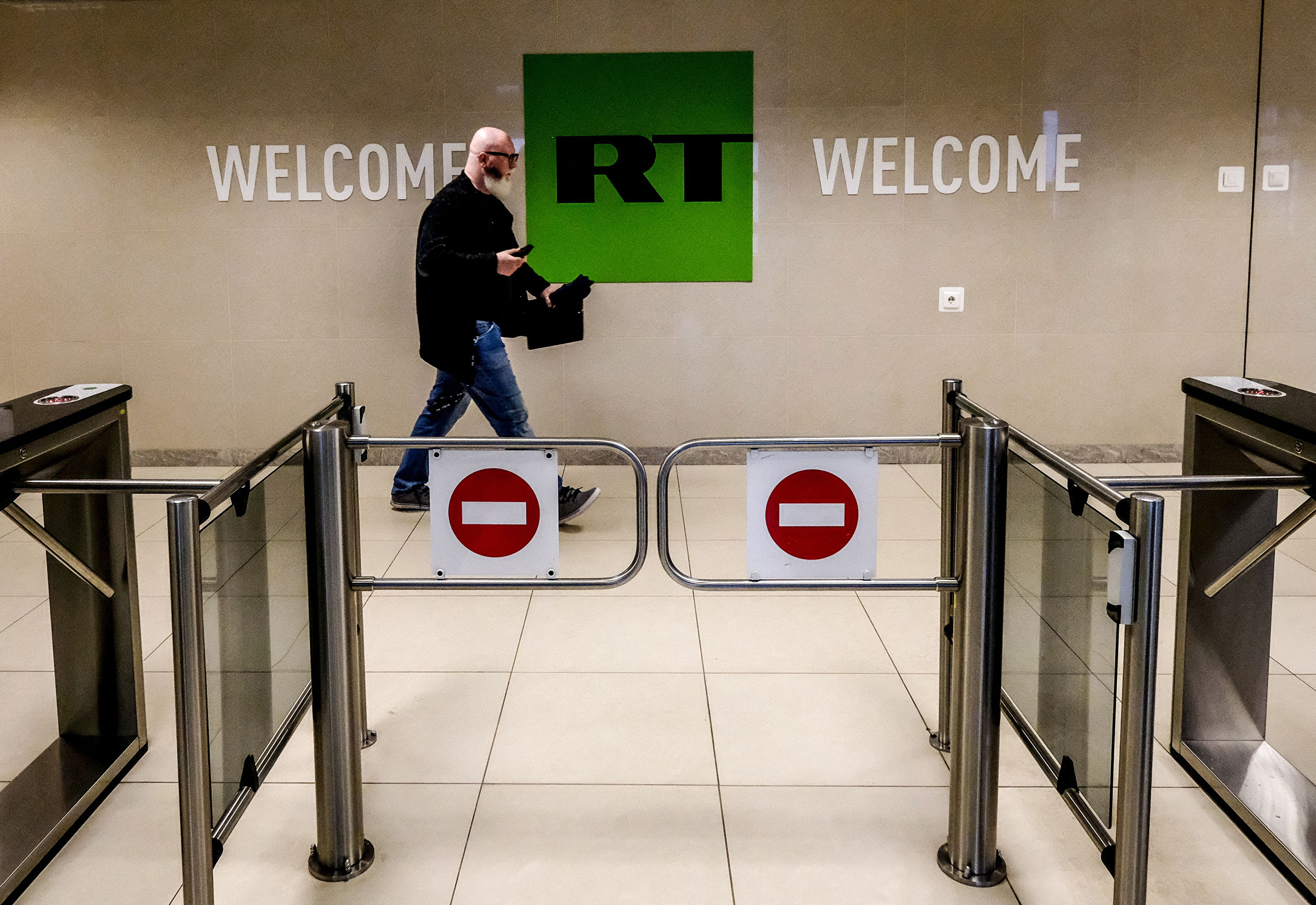 A man passes a control post of the Russia Today TV company in Moscow, June 2018. Russian state-controlled media outlets RT and Sputnik will be banned in the European Union, announced European Commission President Ursula von der Leyen in February 2022. (Yuri Kadobnov—AFP/Getty Images)