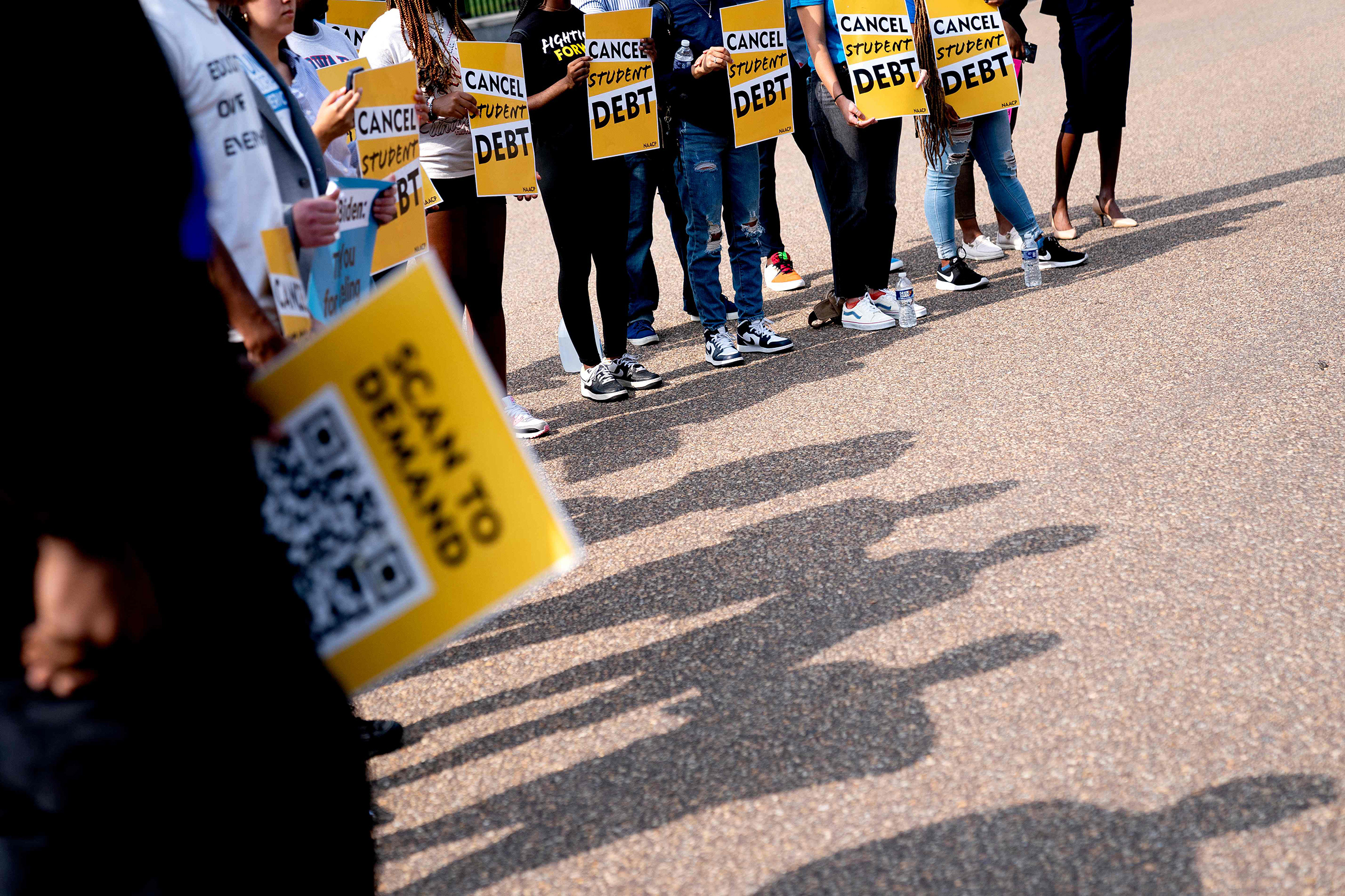 Activists hold cancel student debt signs as they gather to rally in front of the White House in Washington D.C., Aug. 25, 2022. (Stefani Reynolds—AFP/Getty Images)
