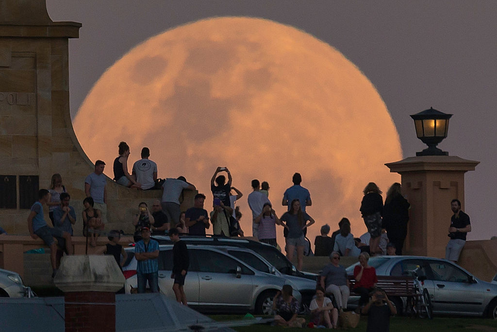 Crowds look on as the supermoon rises behind the Fremantle War Memorial at Monument Hill on Nov. 14, 2016, in Fremantle, Australia. (Paul Kane—Getty Images)