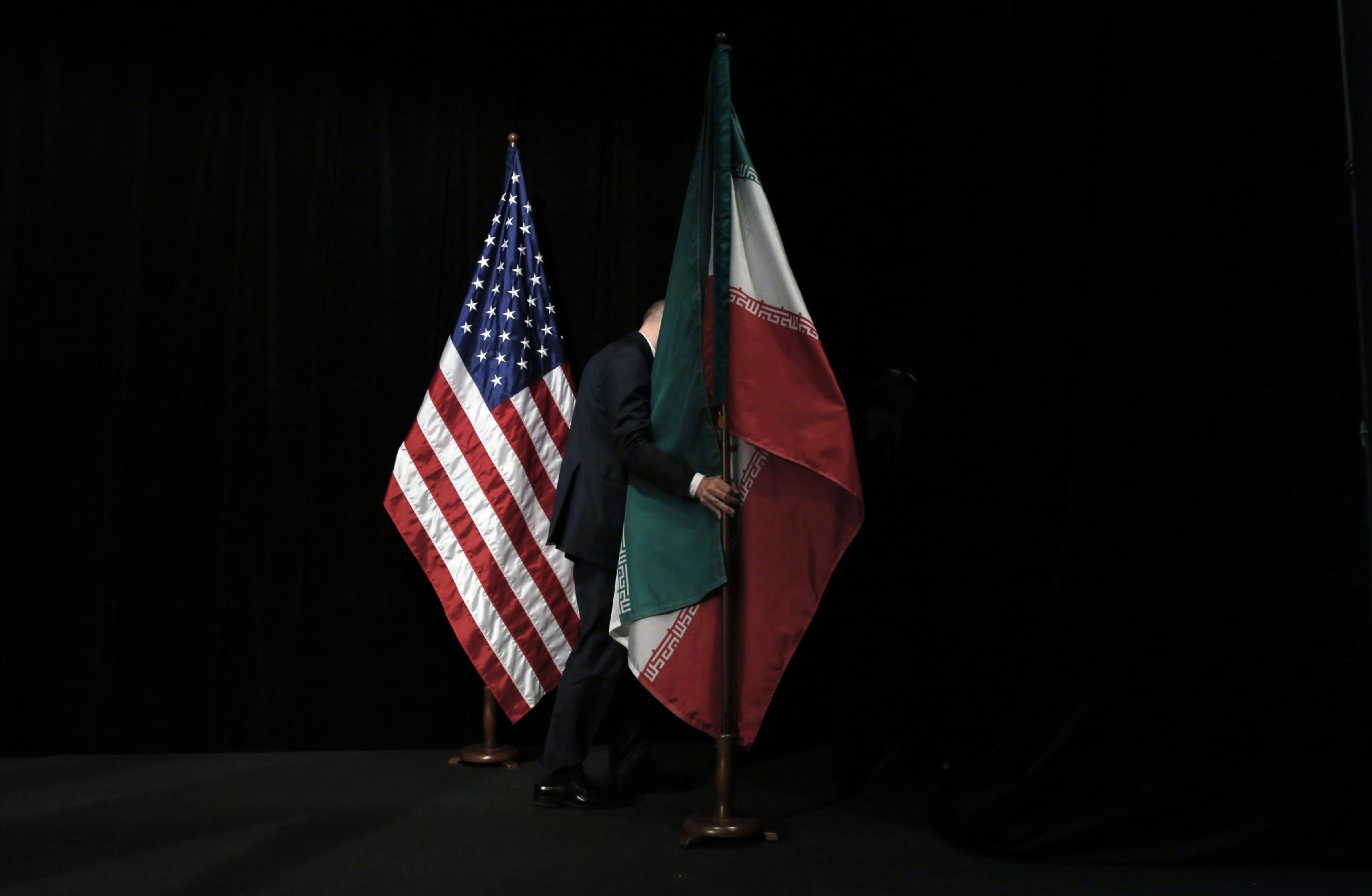 A staff member removes the Iranian flag from the stage after the Iran nuclear talks at Austria International Centre in Vienna, Austria on July 14, 2015. (AFP/Getty Images)