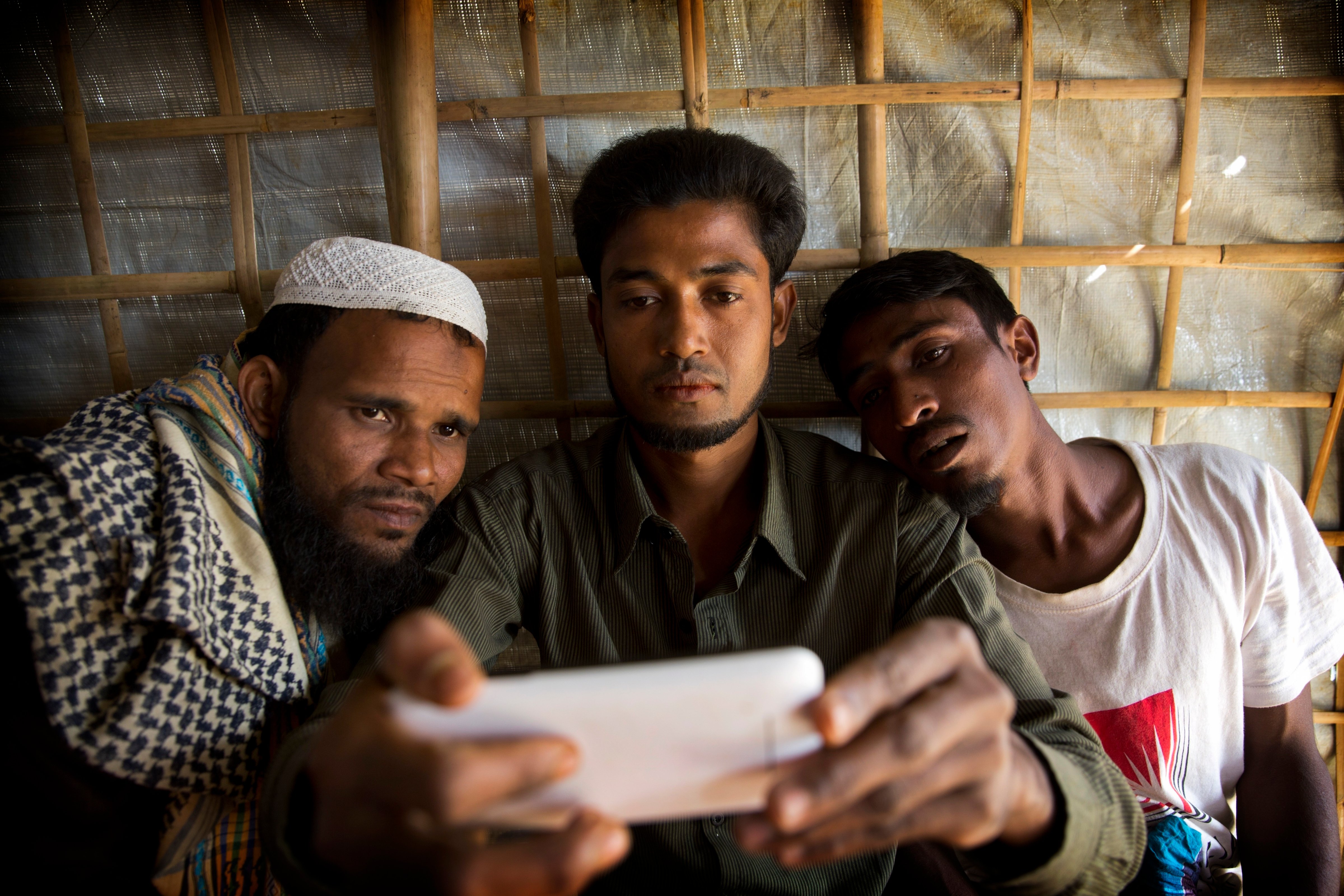 Refugiados rohingya miran un teléfono celular en el campo de refugiados de Kutupalong en Bangladesh el 14 de enero de 2018. (Manish Swarup—AP)