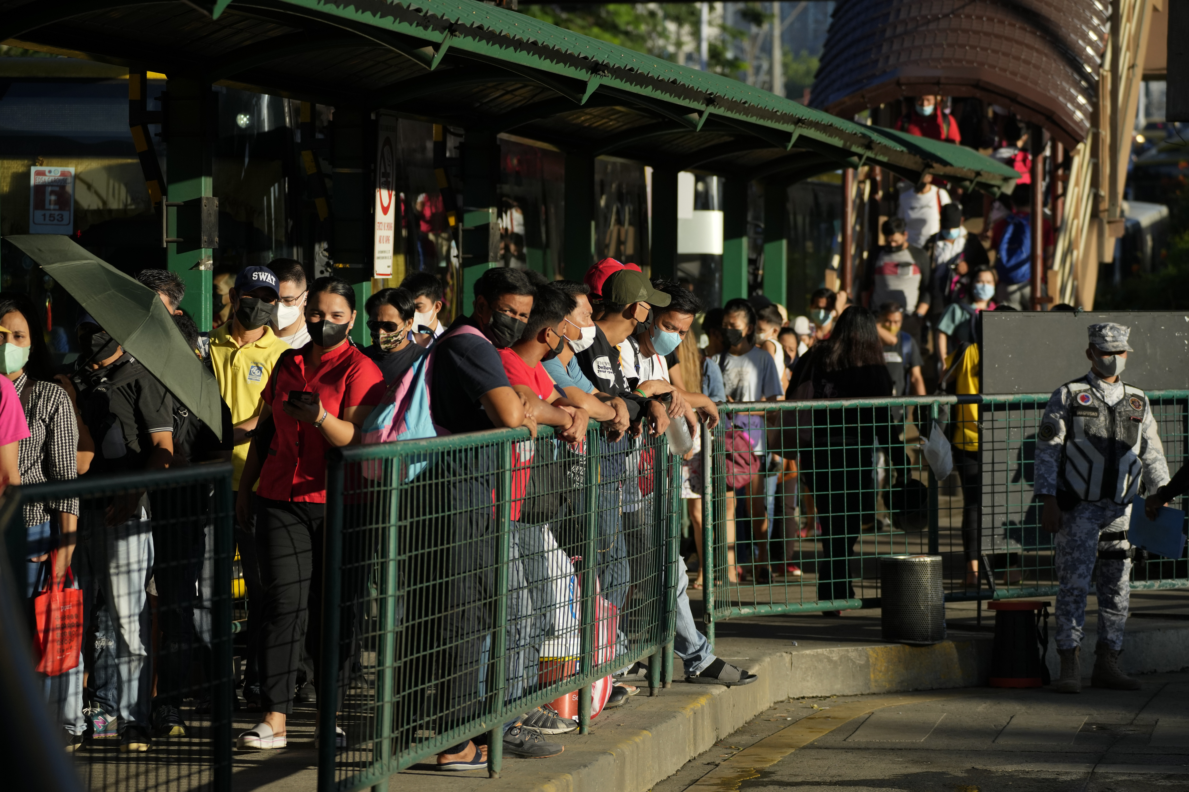 Commuters wearing face masks wait for a ride at a bus stop in Manila, Thursday, Sept. 8, 2022. (AP Photo/Aaron Favila)