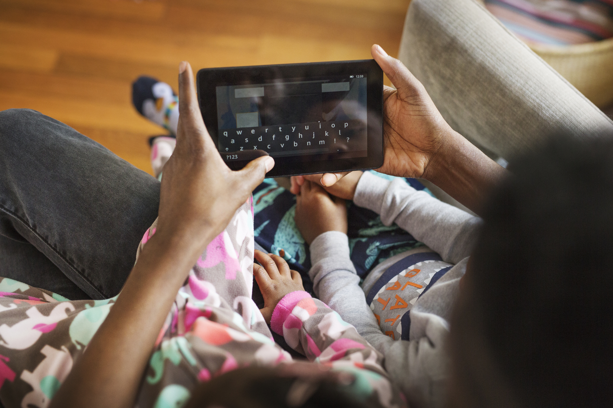 View of a parent using tablet computer with a child at home