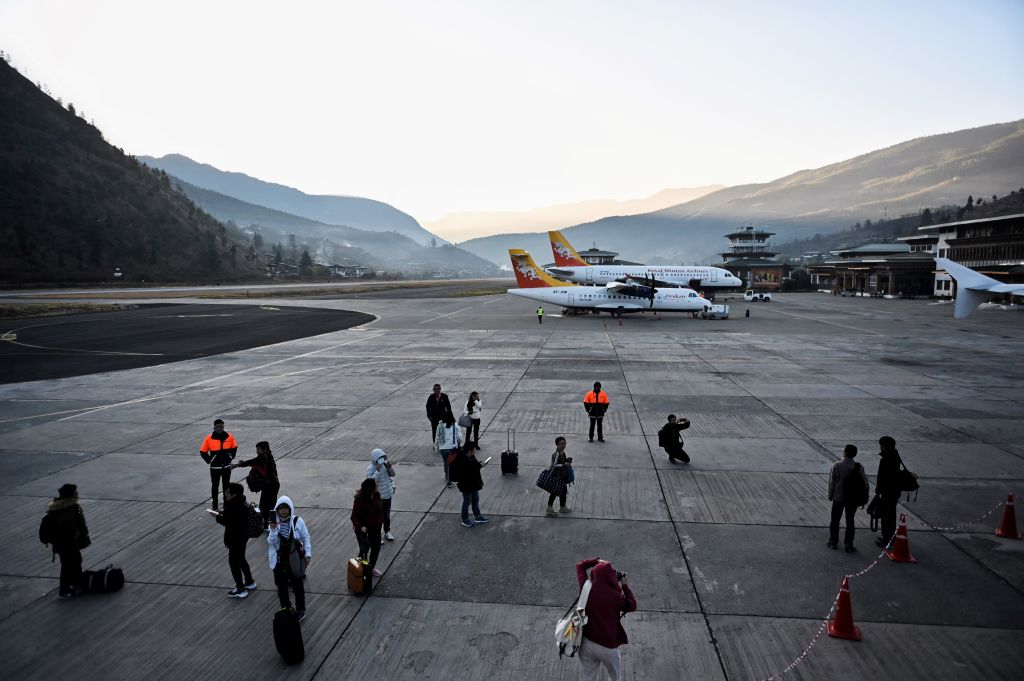 Tourists arrive on the tarmac at Paro International Airport in Paro, Bhutan on Dec. 5, 2019. (LILLIAN SUWANRUMPHA/AFP via Getty Images)
