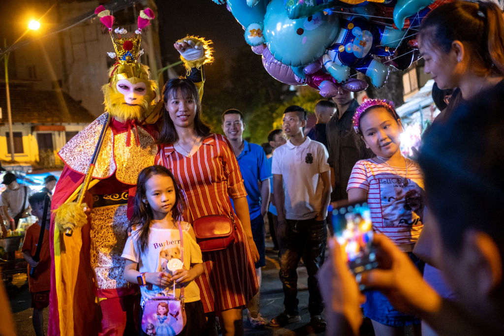 Návštěvníci se 26. září 2020 v Hanoji ve Vietnamu vyfotí s opičím králem v kostýmech z čínské mytologie.  Festival poloviny podzimu je příležitostí pro dětský večer a rodinné setkání (Linh Pham/Getty Images)