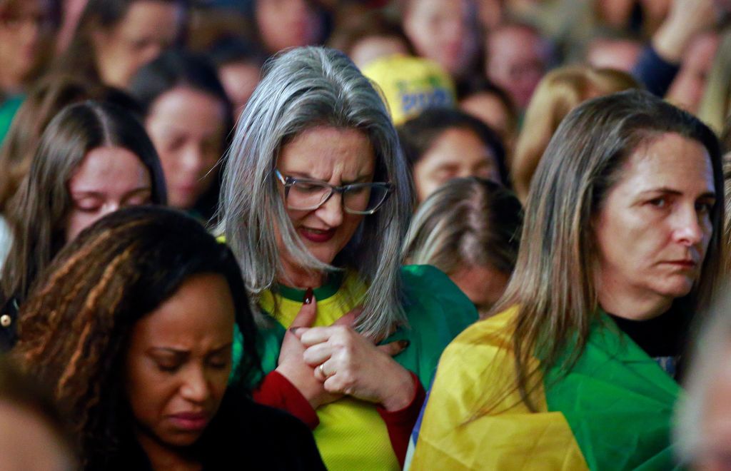 Las mujeres rezan durante el evento 'Mujeres por la vida y la familia' organizado por el Partido Liberal-Mujeres en apoyo a Bolsonaro, en Novo Hamburgo, estado de Rio Grande do Sul, Brasil, el 3 de septiembre de 2022. (SILVIO AVILA/AFP vía Getty Imágenes)