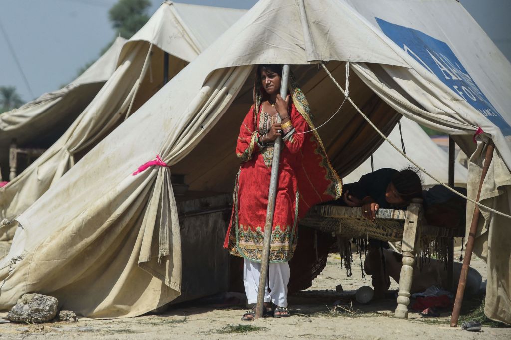 A displaced woman stands inside a tent at a makeshift camp near a flooded area following heavy monsoon rains in Rajanpur district of Punjab province on Sept. 4, 2022. (ARIF ALI/AFP via Getty Images)