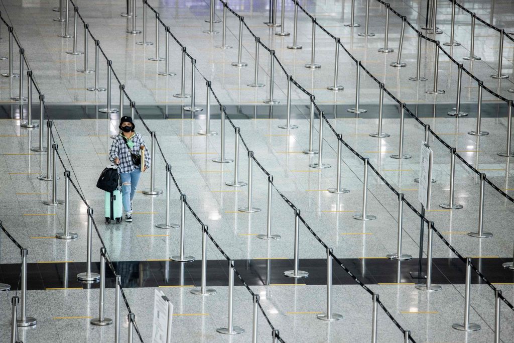 A woman arrives at Hong Kong International Airport before making her way to hotel quarantine on September 23, 2022. (ISAAC LAWRENCE/AFP via Getty Images)