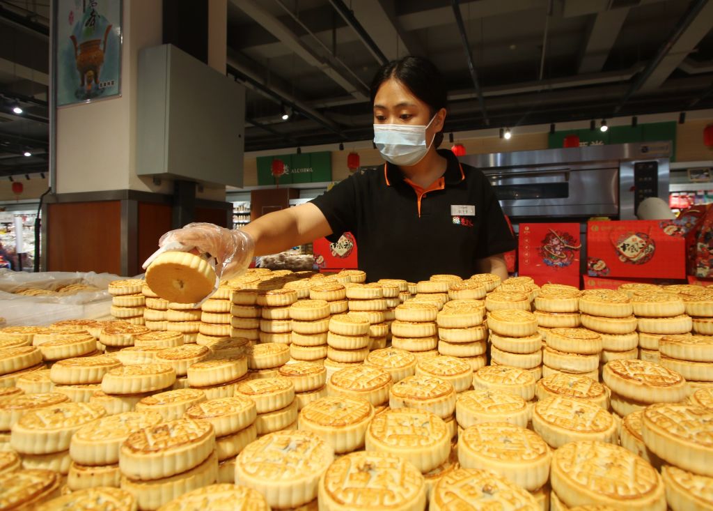 Když se blíží svátek poloviny podzimu, 5. září 2022, Handan, provincie Hebei, Čína, zaměstnanec připravuje měsíční koláče v supermarketu.  (VCG/VCG přes Getty Images)