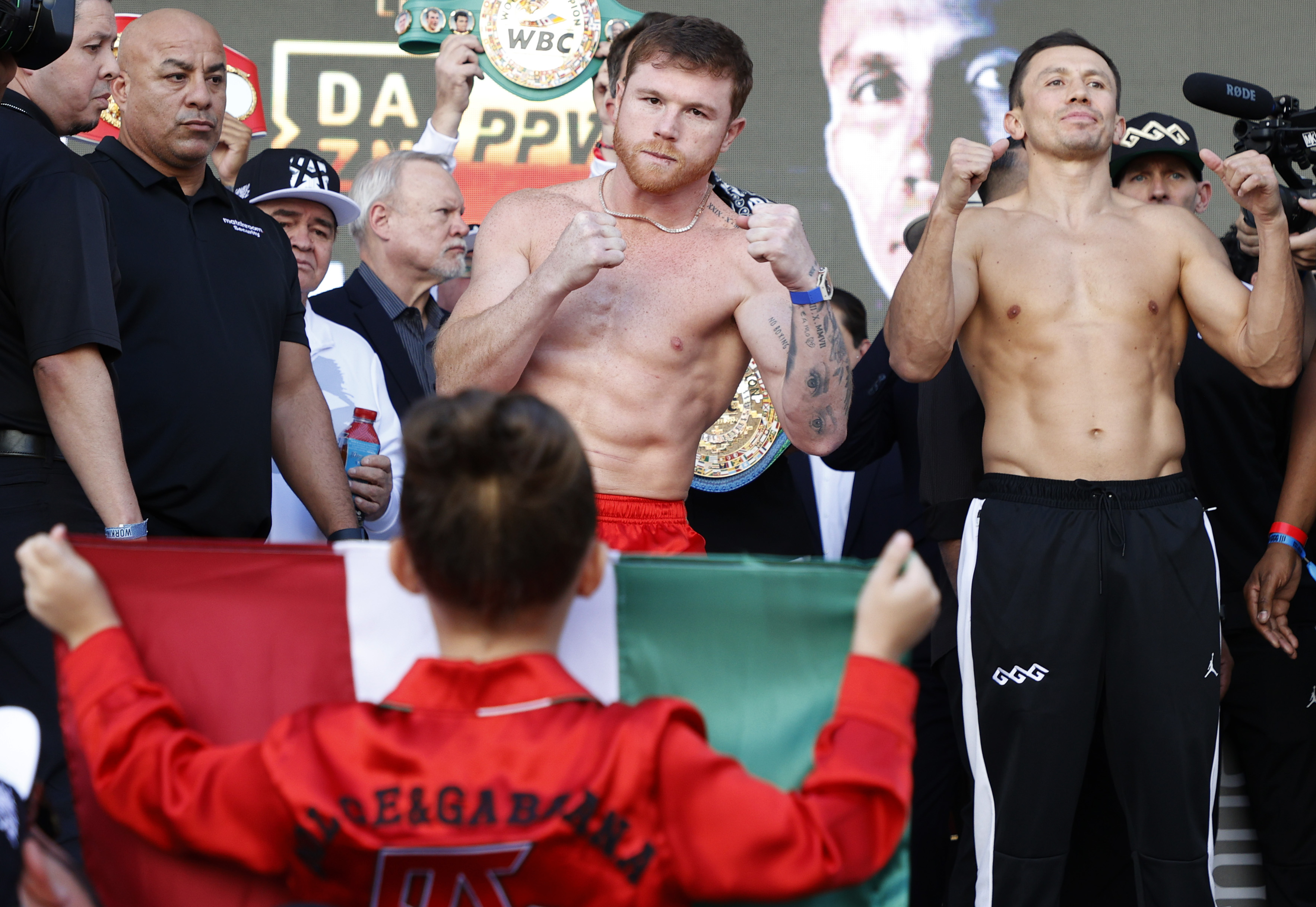 Canelo Alvarez of Mexico (L) and Gennadiy Golovkin of Kazakhstan (R) pose as Alvarez's daughter, Maria Fernanda Alvarez, holds the Mexican national flag during a ceremonial weigh-in at Toshiba Plaza on September 16, 2022 in Las Vegas, Nevada. Alvarez and Golovkin will meet for the undisputed super middleweight title bout at T-Mobile Arena in Las Vegas on September 17. (Photo by Sarah Stier—Getty Images)