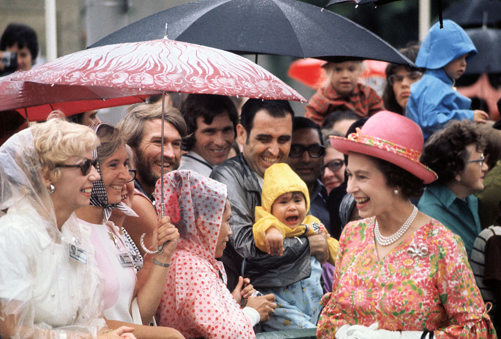 Queen Elizabeth II greets onlookers in light rain outside the National Arts Centre in Ottawa, Canada, on Aug. 1, 1973. (Bettmann Archive)