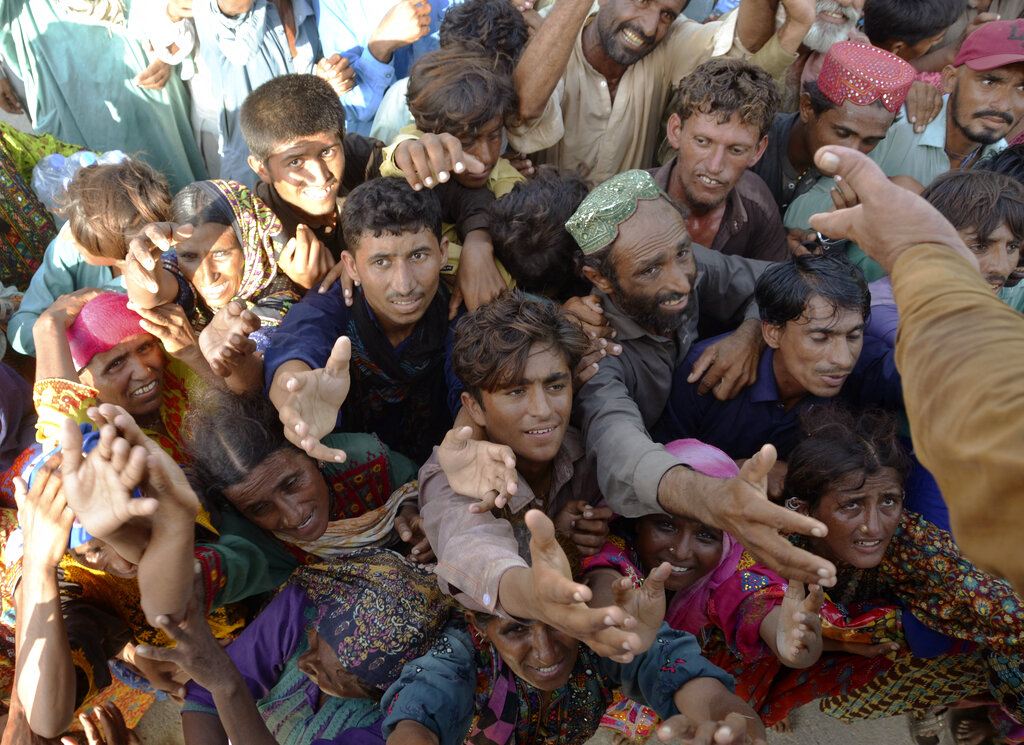 Displaced families, who fled their flood-hit homes, jostle to get relief aid distributed by soldiers of Pakistan rangers, in Dera Allahyar, in Jaffarabad, a district of southwestern Balochistan province on Sept. 17, 2022. (Zahid Hussain—AP)