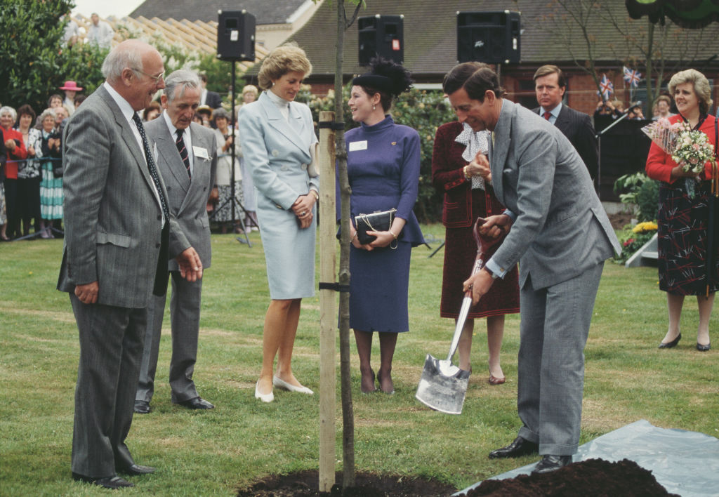 Prens Charles ve Diana, Galler Prensesi Chester, İngiltere, Mayıs 1988'de ağaç dikiyor. Diana, Arabella Polen imzalı bir takım elbise giyiyor.  (Terry Fincher/Prenses Diana Arşivi—Getty Images)
