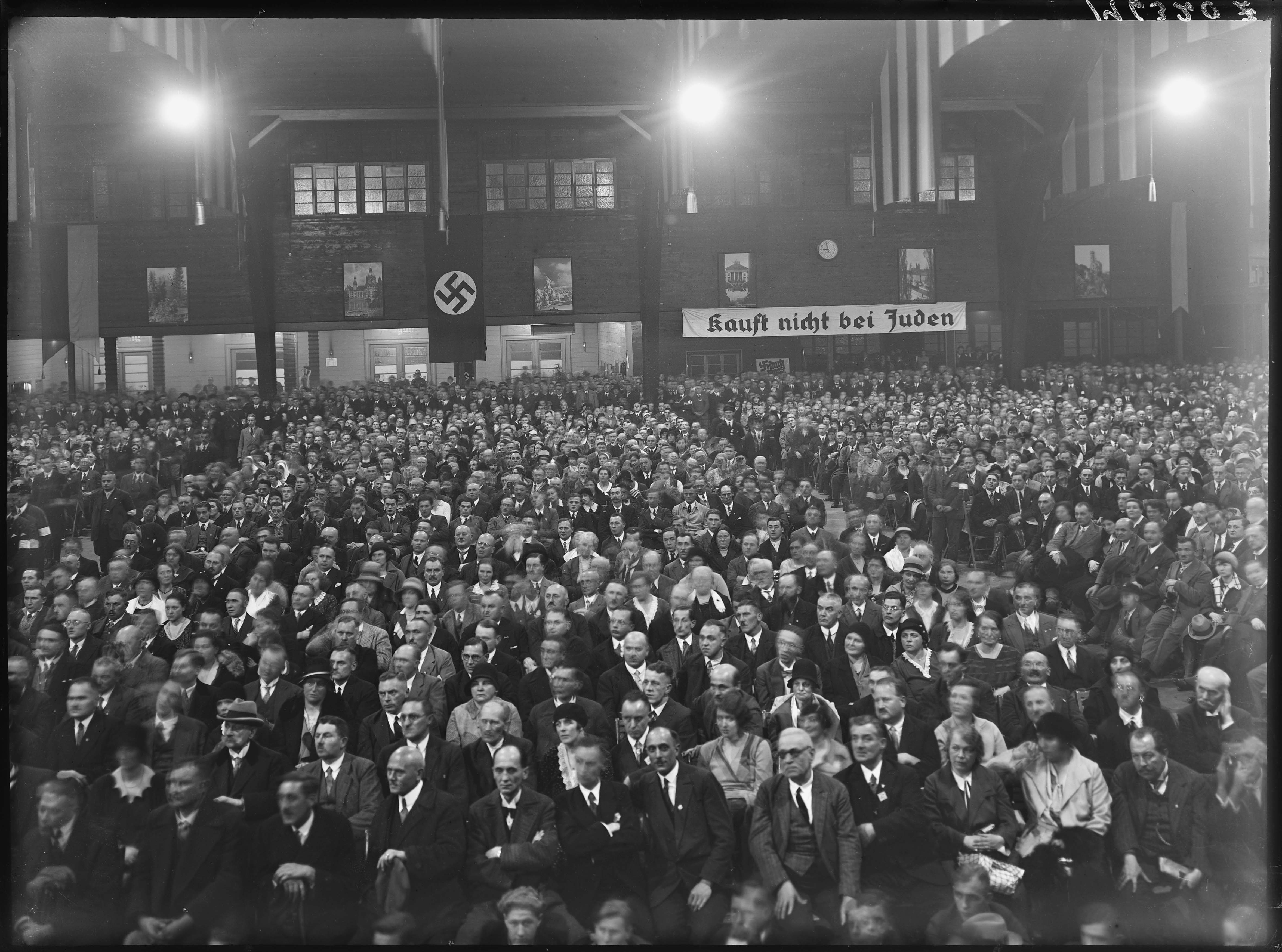 Party meeting or rally. Sign in the back reads: 