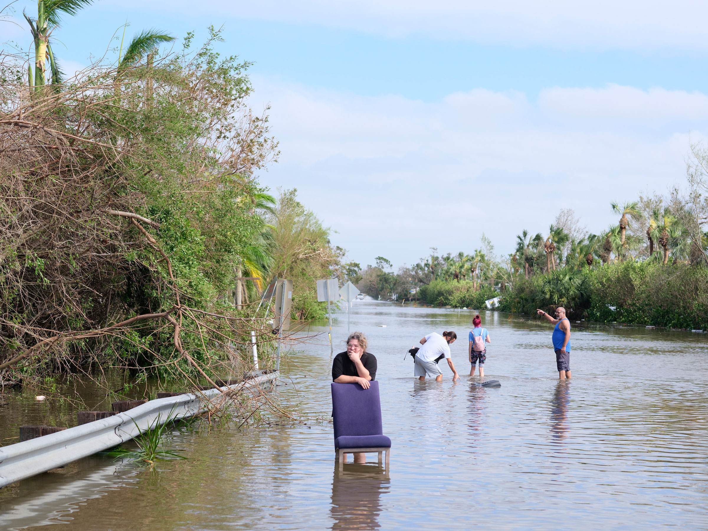 Homeowners in Fort Myers, Fla., walk outside their homes on Sept. 29, 2022 to assess damage and wait for help from relatives. (Christopher Morris for TIME)