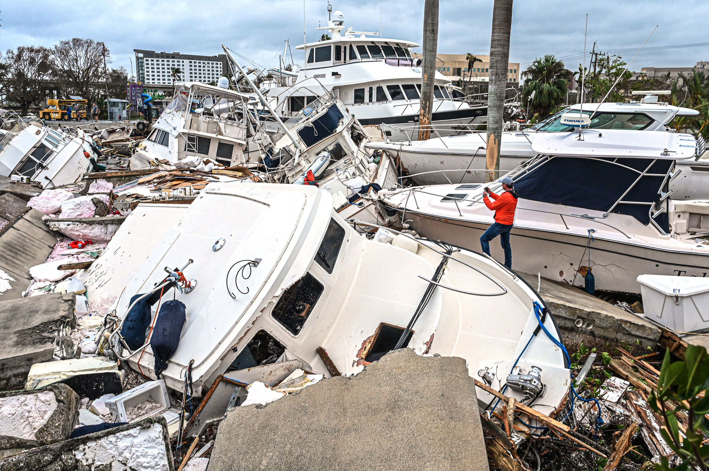 A man takes photos of boats damaged by Hurricane Ian in Fort Myers, Fla., on Sept. 29. (Giorgio Viera—AFP/Getty Images)