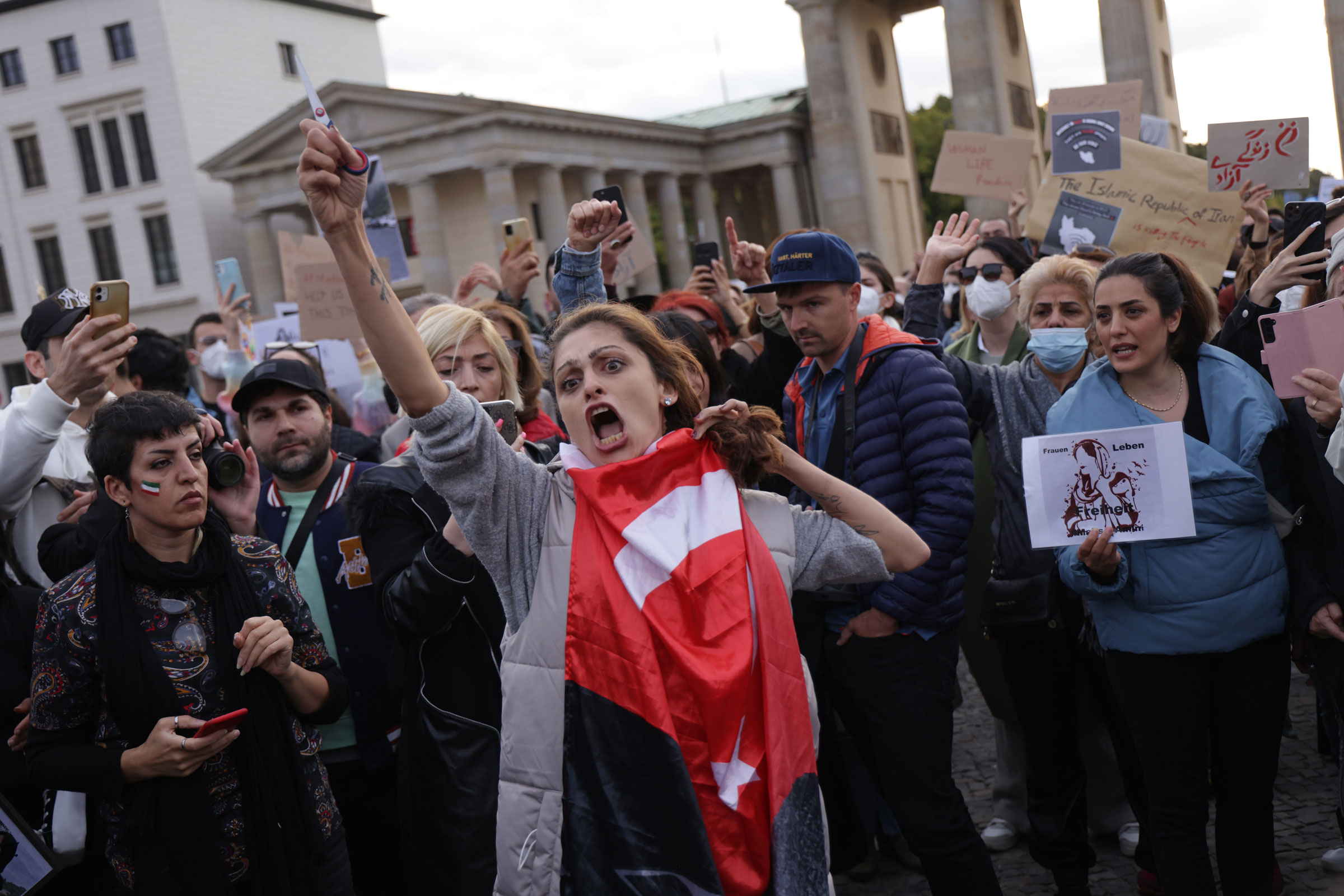 <b>Berlin, Almanya</b> İran’da 23 Eylül 2022’deki bir gösteri sırasında bir kadın protestocu saçlarını makasla keserken bağırıyor. (Sean Gallup—Getty Images)” class=”fix-layout-shift”/></source></source></source></source></source></picture></figure>
<div class=