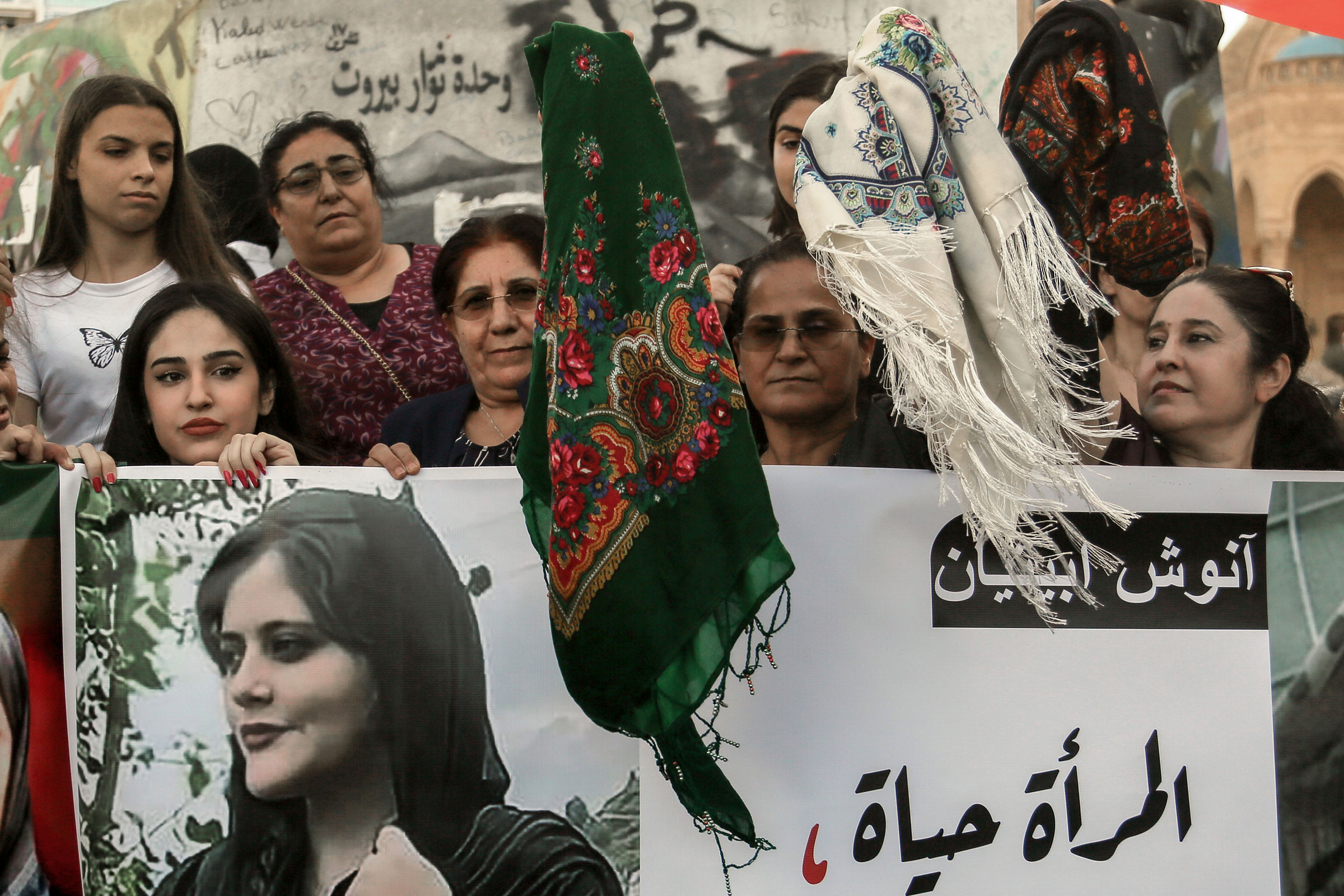 <b>Lebanon, Beirut</b> On 21 Sept. 2022, Kurdish women wave head scarves while they hold pictures of Mahasa Amini. (Marwan Naamani—AP)