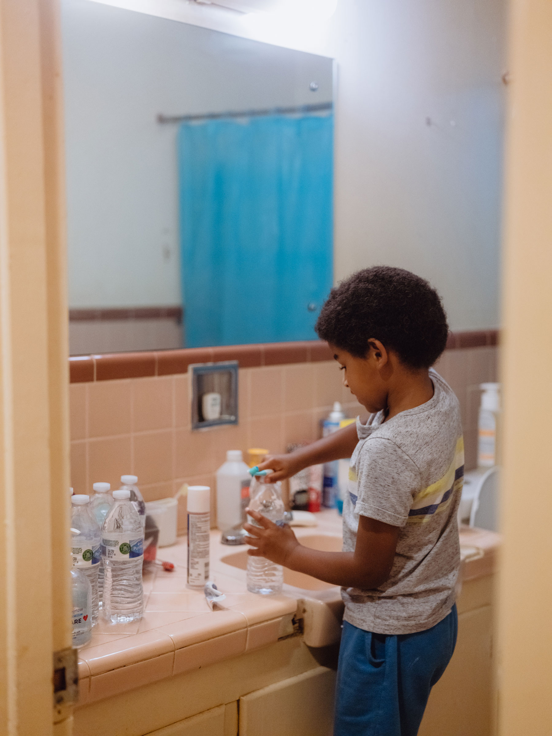 Langston Floyd, 6, uses bottled water to brush his teeth on Sep. 5, 2022 in Jackson. The day to day challenges of having to use bottled or boiled water for almost every aspect of their life is not a new concept for the Floyd family. For the majority of Langston's life there have been multiple boil water notices for the city of Jackson every year. (Christopher Lee for TIME)