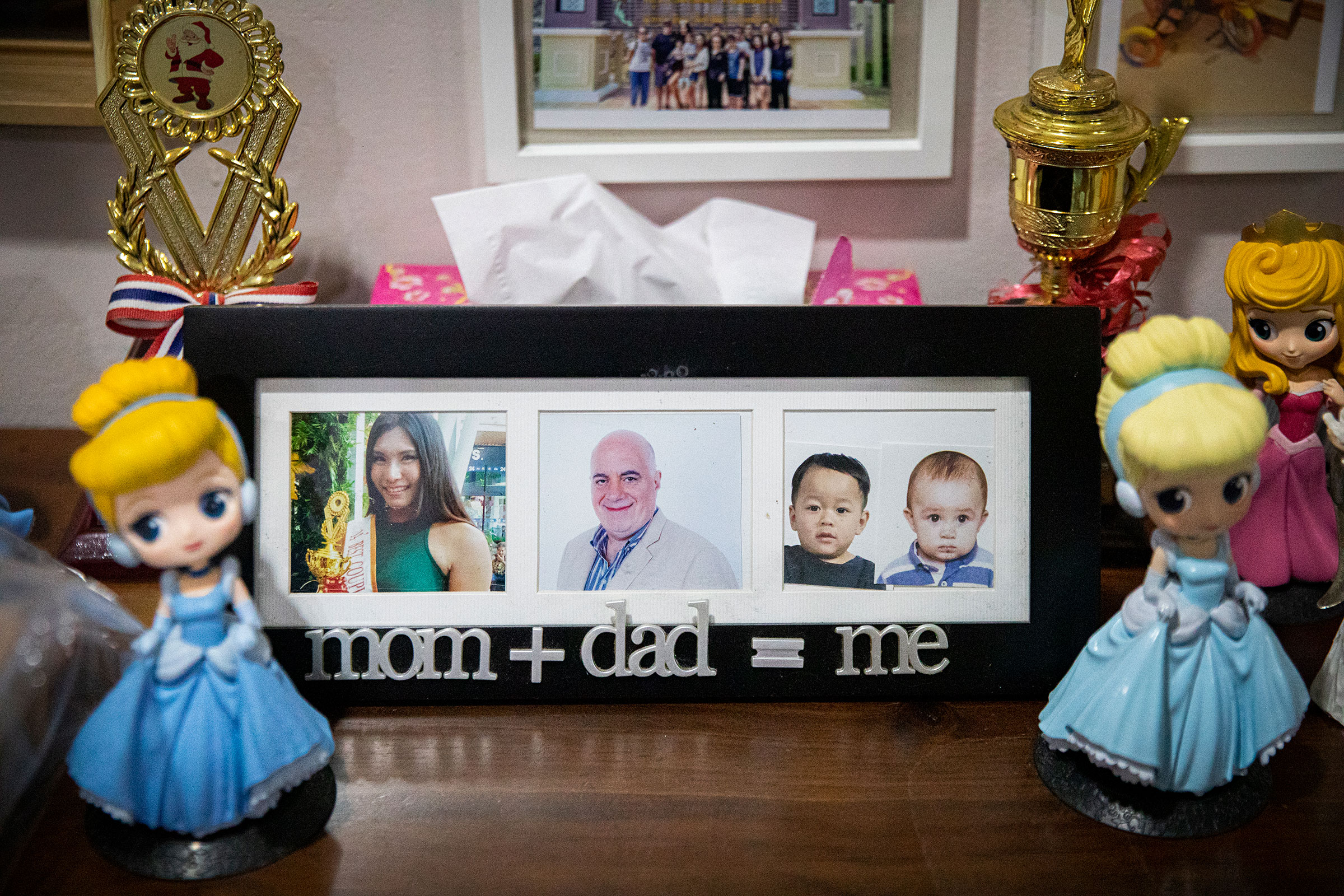Ariya "Gina" Milintanapa and her partner, Lee Battia, have photos of them and their two sons on display in their family home on July 12, 2022 in Bangkok, Thailand.  Ariya "Gina" Milintanapa, a Thai transgender woman, and her American partner, Lee Battia, live in Bangkok, Thailand with their two children, Chene, 8, and Charlie, 6. Although the couple has been together for nearly 20 years, due to the country's conservative marriage laws, Gina and Lee have been unable to officially marry in Thailand, leading to struggles over joint guardianship of their two children. Under current laws, Lee currently has guardianship rights to Chene and Gina has guardianship rights to Charlie. While globally Thailand is considered an inclusive and accepting country for LGBTQ communities and tourists, those living in Thailand struggle for equal rights as courts historically ruled against same-sex marriage. Couples like Gina and Lee hold out hope for joint custody as Thailand's parliament preliminarily approved a bill to recognize same-sex marriage on June 15, 2022. Photo by Lauren DeCicca for TIME