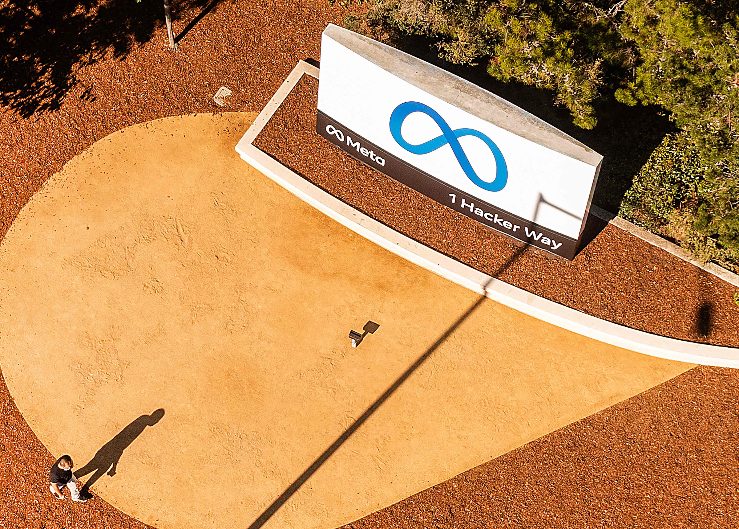 An aerial view shows a person passing a newly unveiled logo for Meta on Oct. 28, 2021 outside Meta headquarters in Menlo Park. (Noah Berger—AFP/Getty Images)