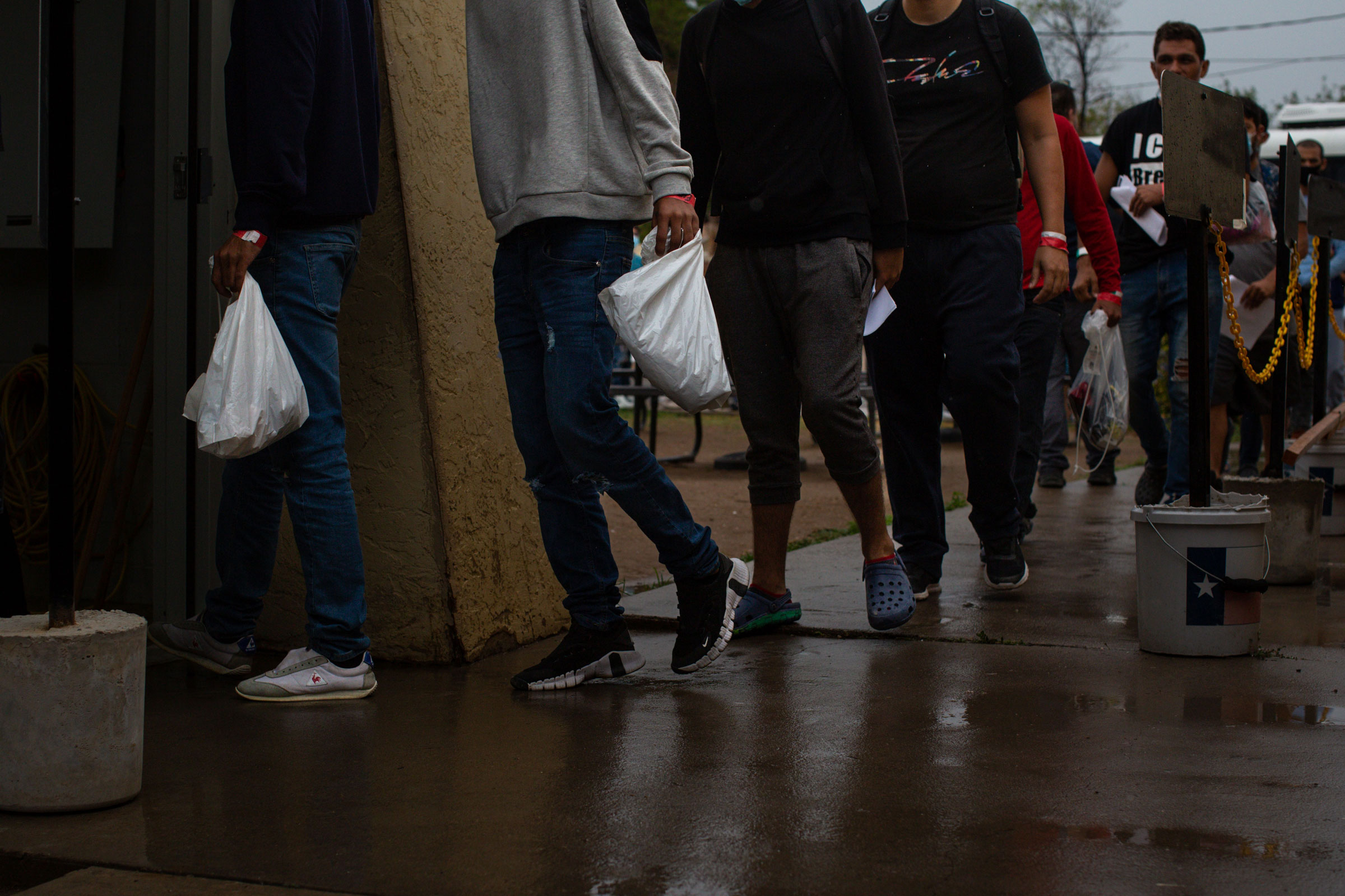 Migrants arrive at the Val Verde Border Humanitarian Coalition carrying plastic bags